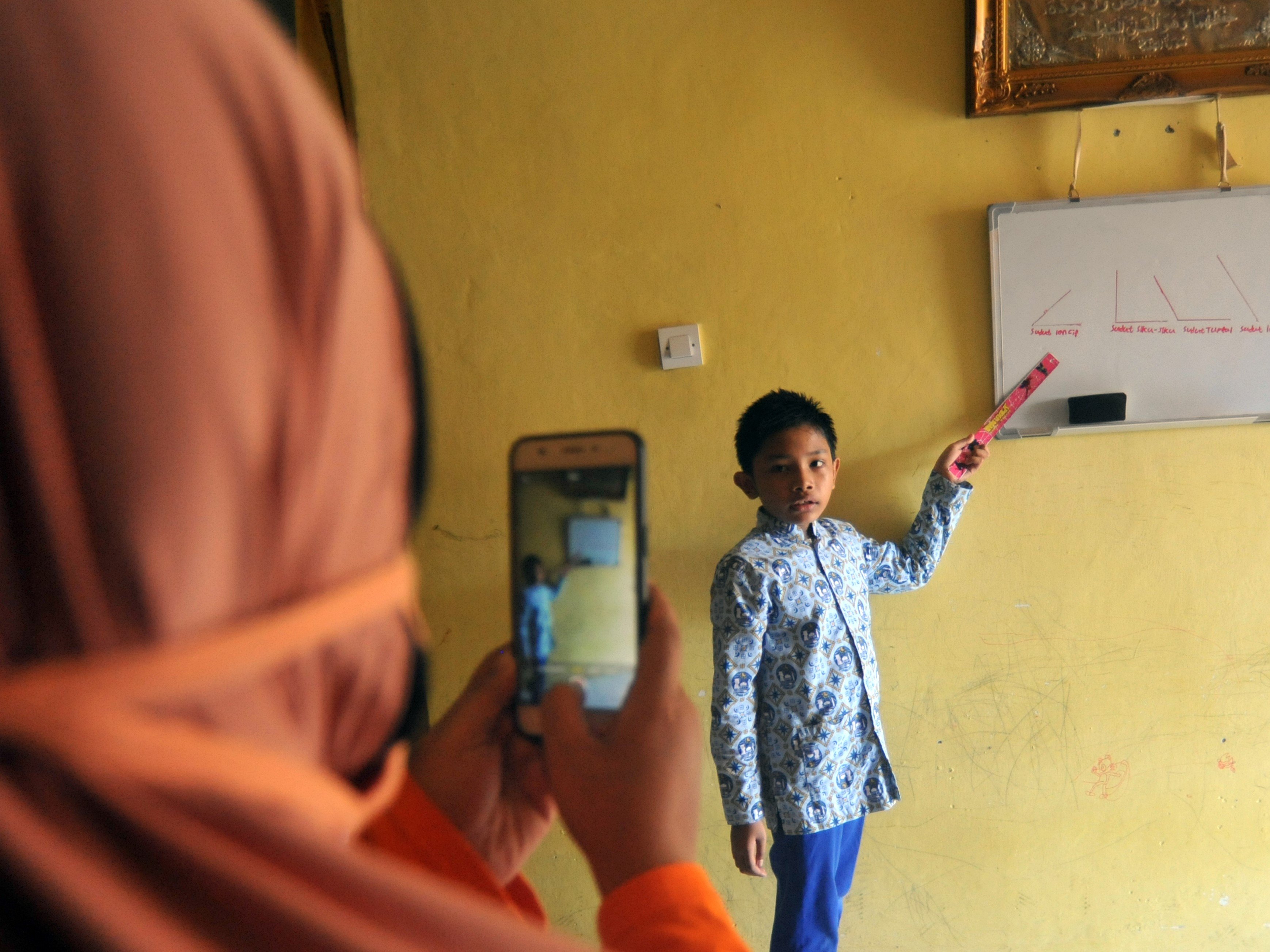 Seorang murid SD membuat video belajar matematika dari rumah untuk sekolah di Desa Rawang, Pariaman, Sumatra Barat.