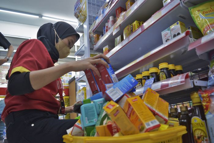 Pegawai minimarket mengumpulkan sejumlah obat sirop terkait kandungan cemaran EG/DEG yang melebihi ambang batas.