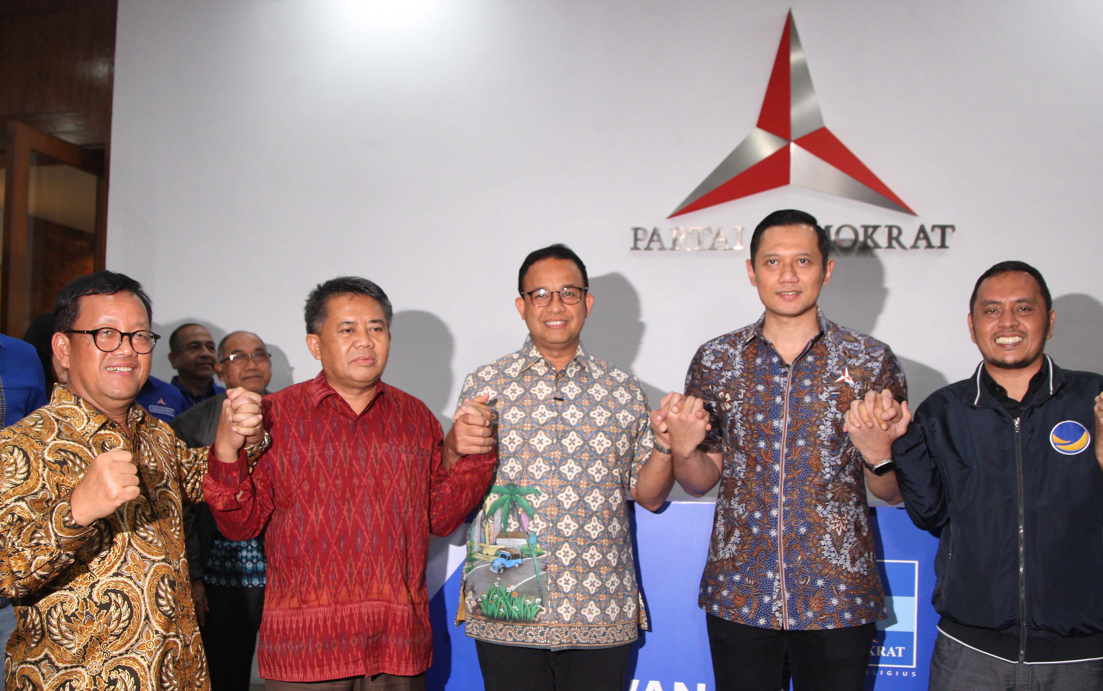 Calon Presiden dari Partai NasDem Anies Baswedan (tengah) mengangkat tangan bersama dengan Ketum Partai Demokrat Agus Harimurti Yudhoyono.
