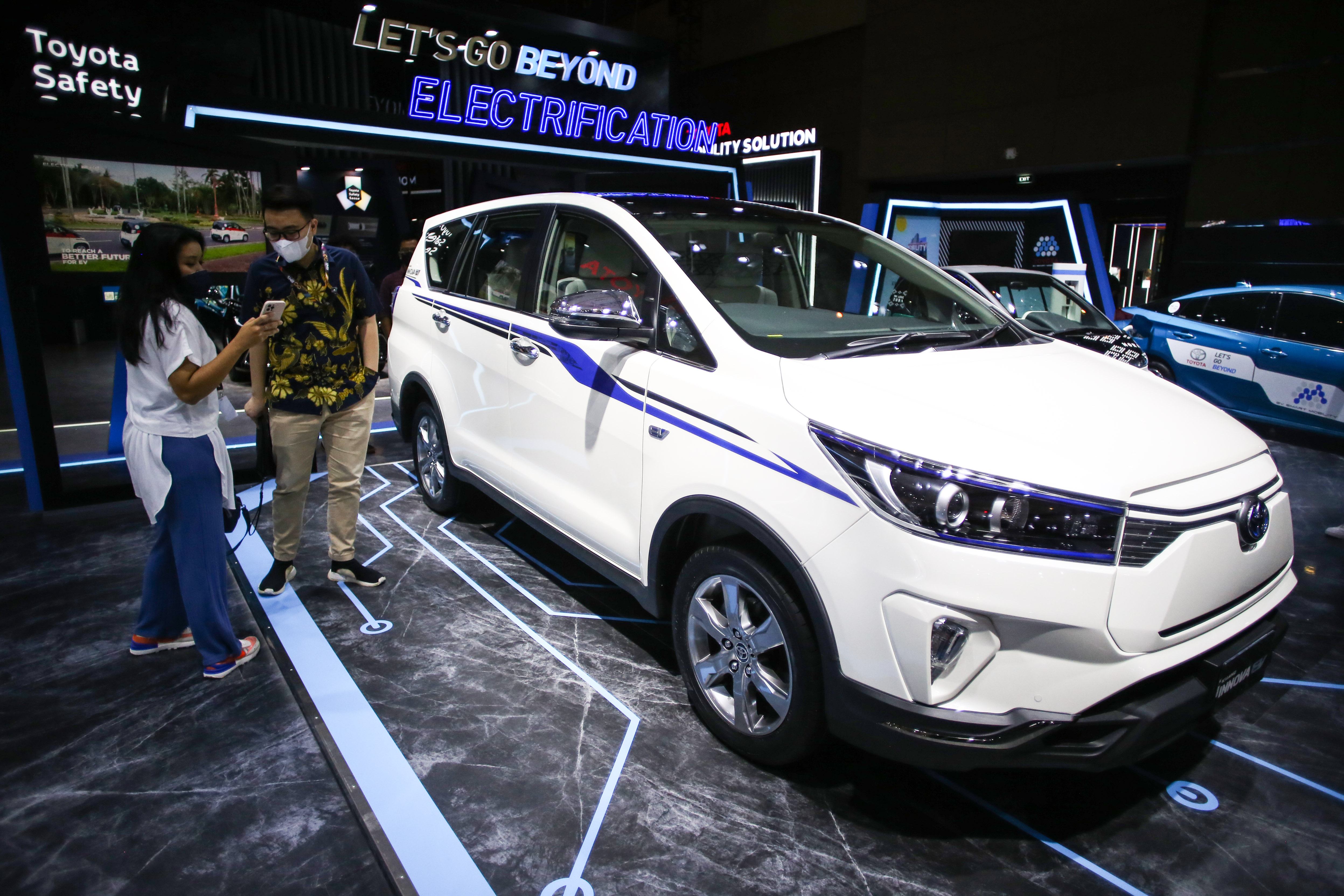 Pengunjung melihat mobil listrik buatan Toyota dalam acara pameran.