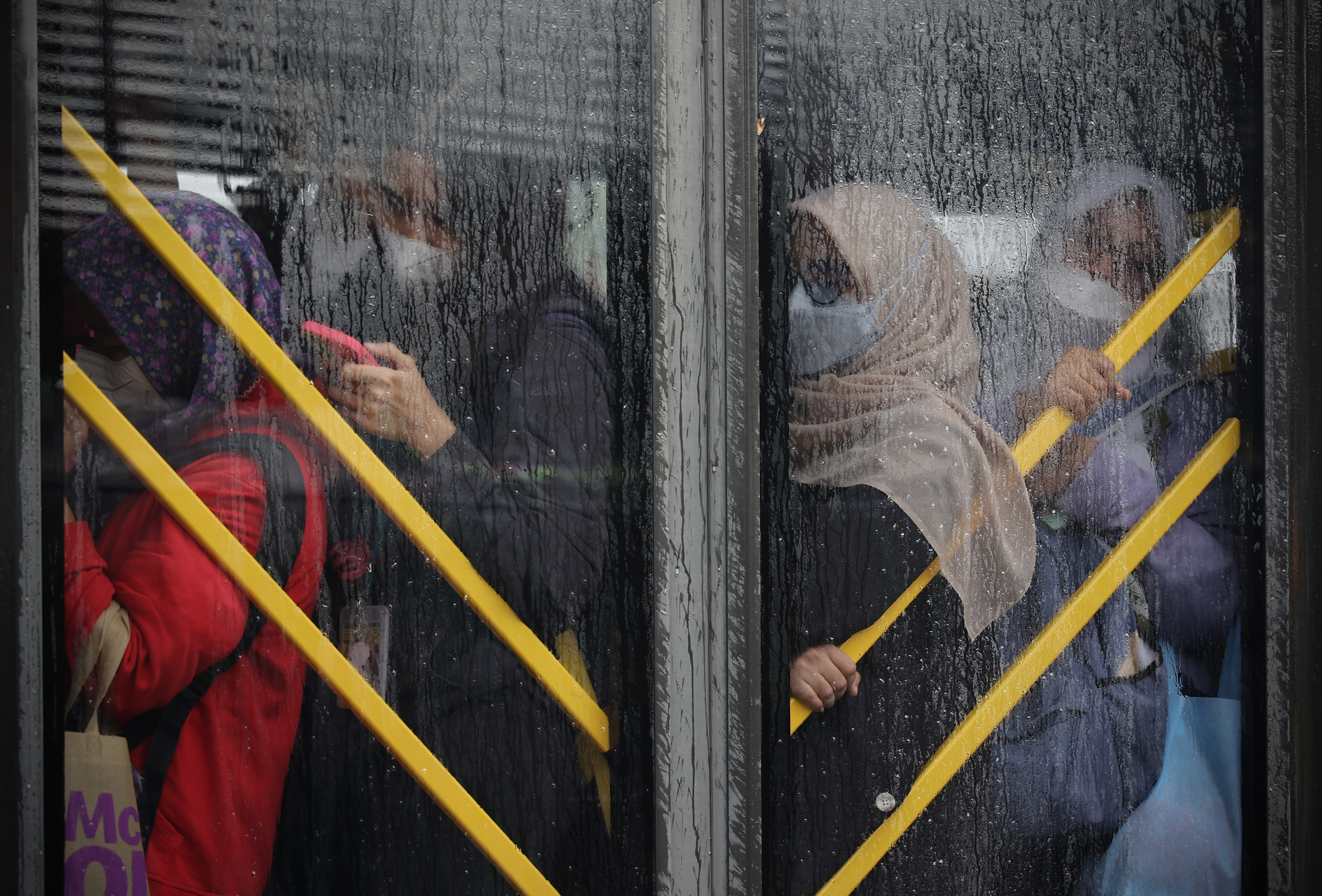 Penumpang perempuan berada di dalam bus TransJakarta yang melintas di Jalan Ciledug Raya, Jakarta.