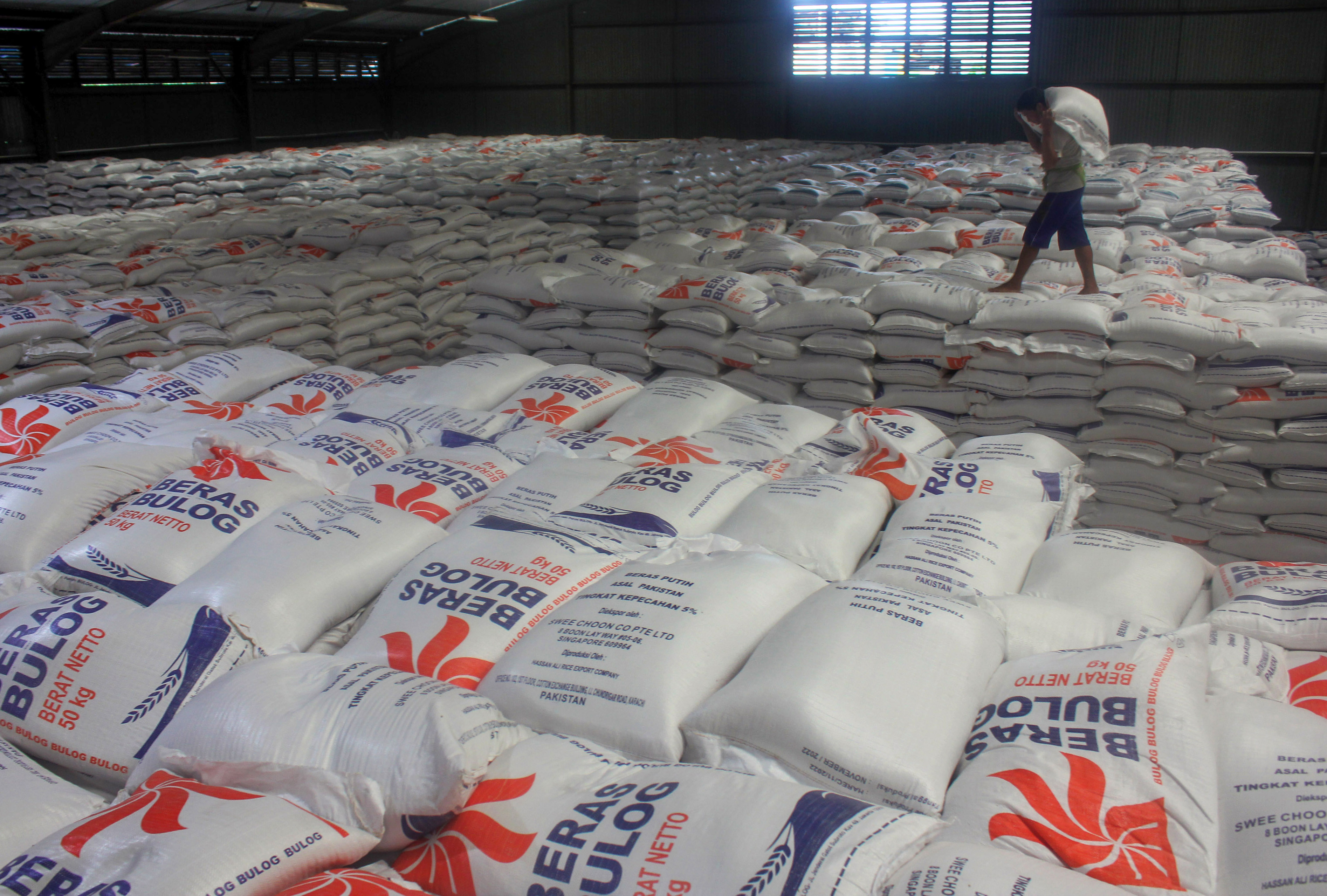 Pekerja mengangkut karung berisi beras di Gudang Bulog Pulo Brayan, Kota Medan, Sumatera Utara, Selasa (24/1/2023).