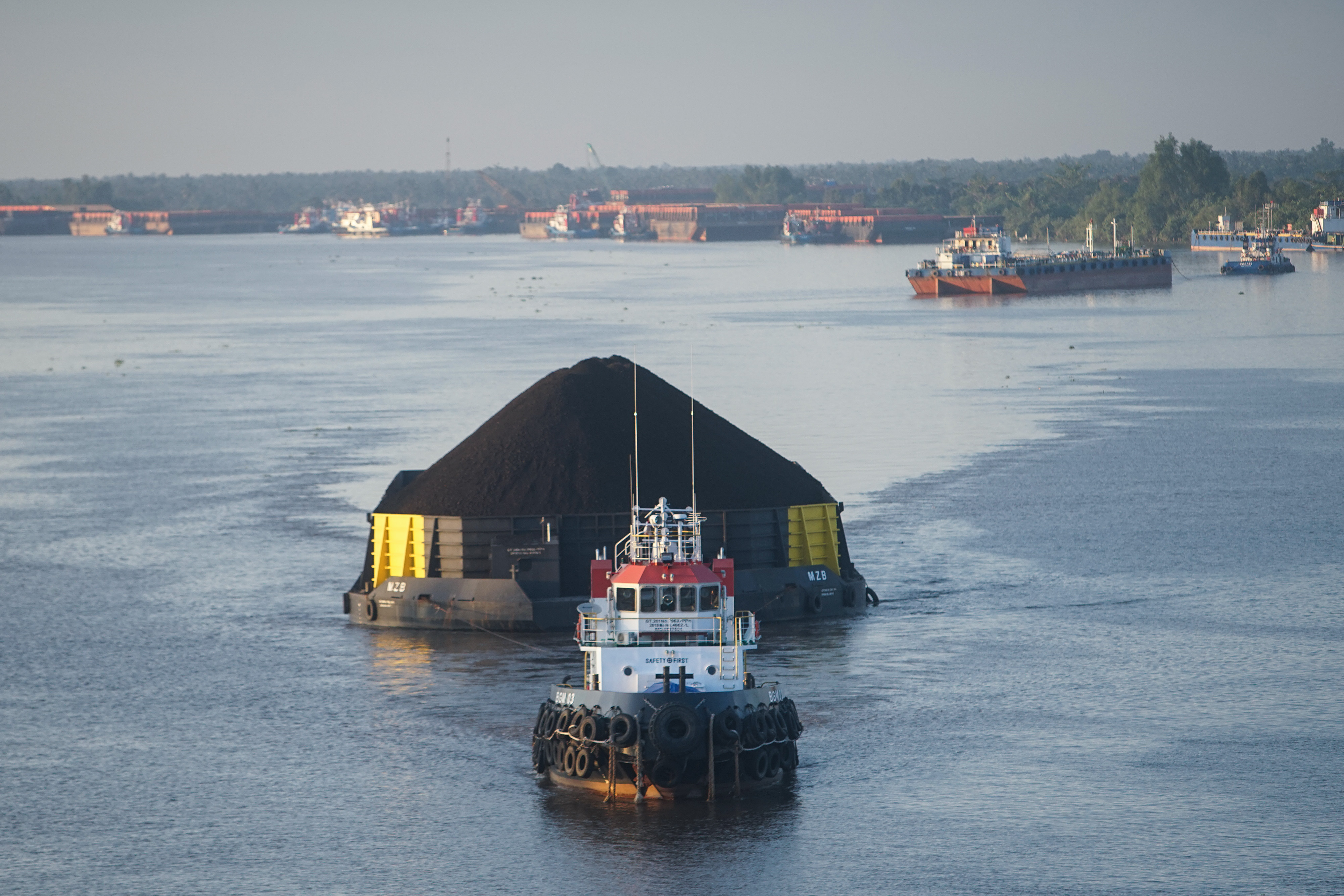 Kapal tongkang pengangkut batu bara melintasi Sungai Barito, Kalimantan Selatan.