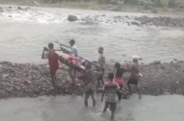 Warga tampak membawa ibu hamil dengan tandu.