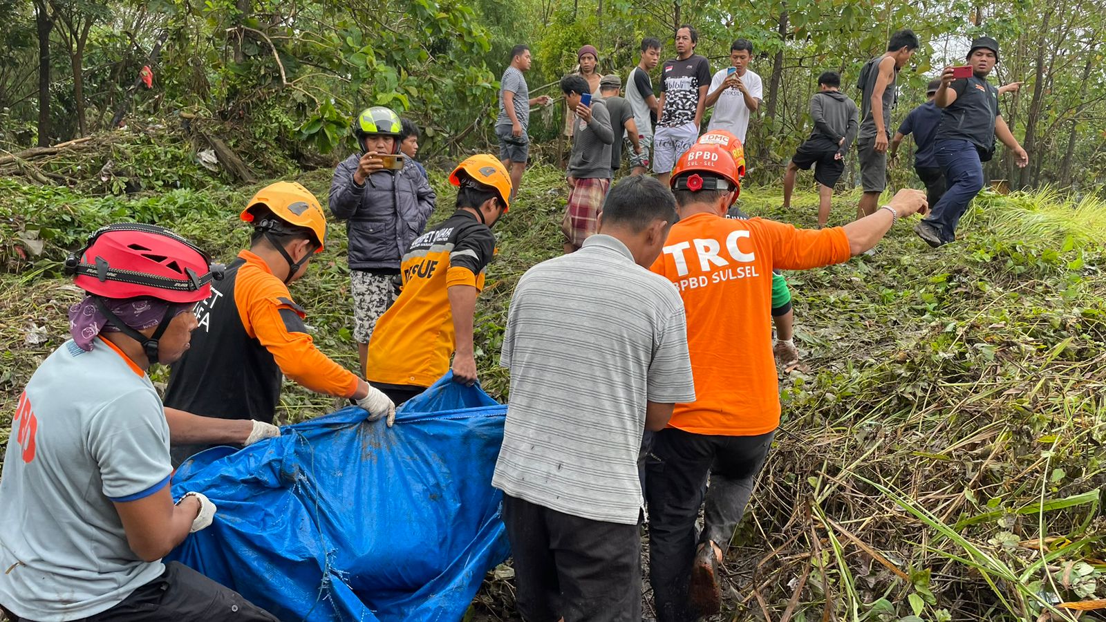 Petugas BPBD mengevakuasi jenazah warga yang hanyut akibat banjir di Parepare, Sulawesi Selatan, Kamis (2/2).