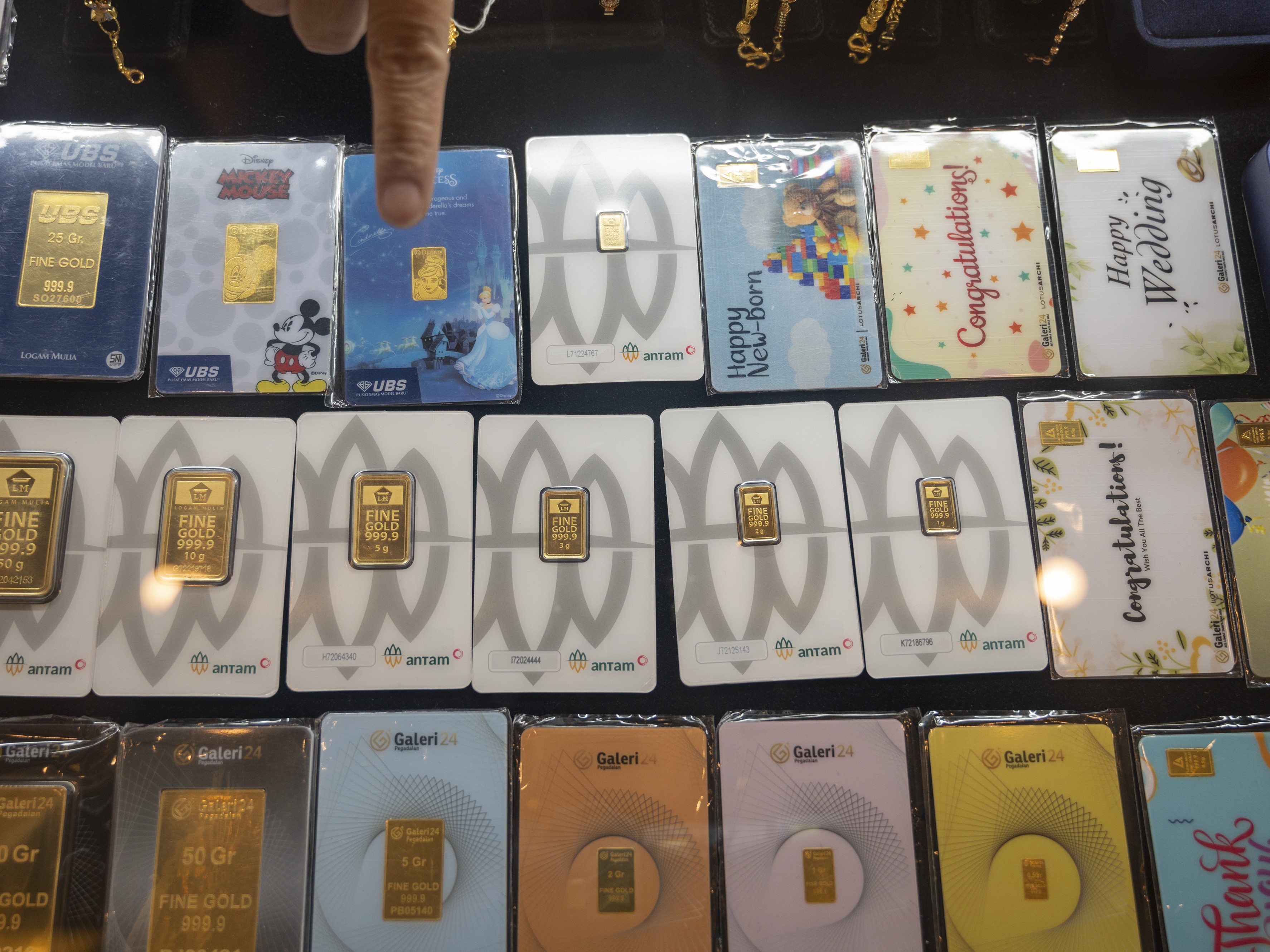 Pegawai menunjukkan pajangan emas cetakan Antam PT Pegadaian (Persero) di Palu, Sulawesi Tengah.