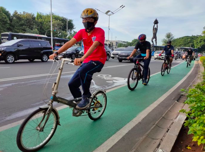Pesepeda melintasi jalan Sudirman, Jakarta.