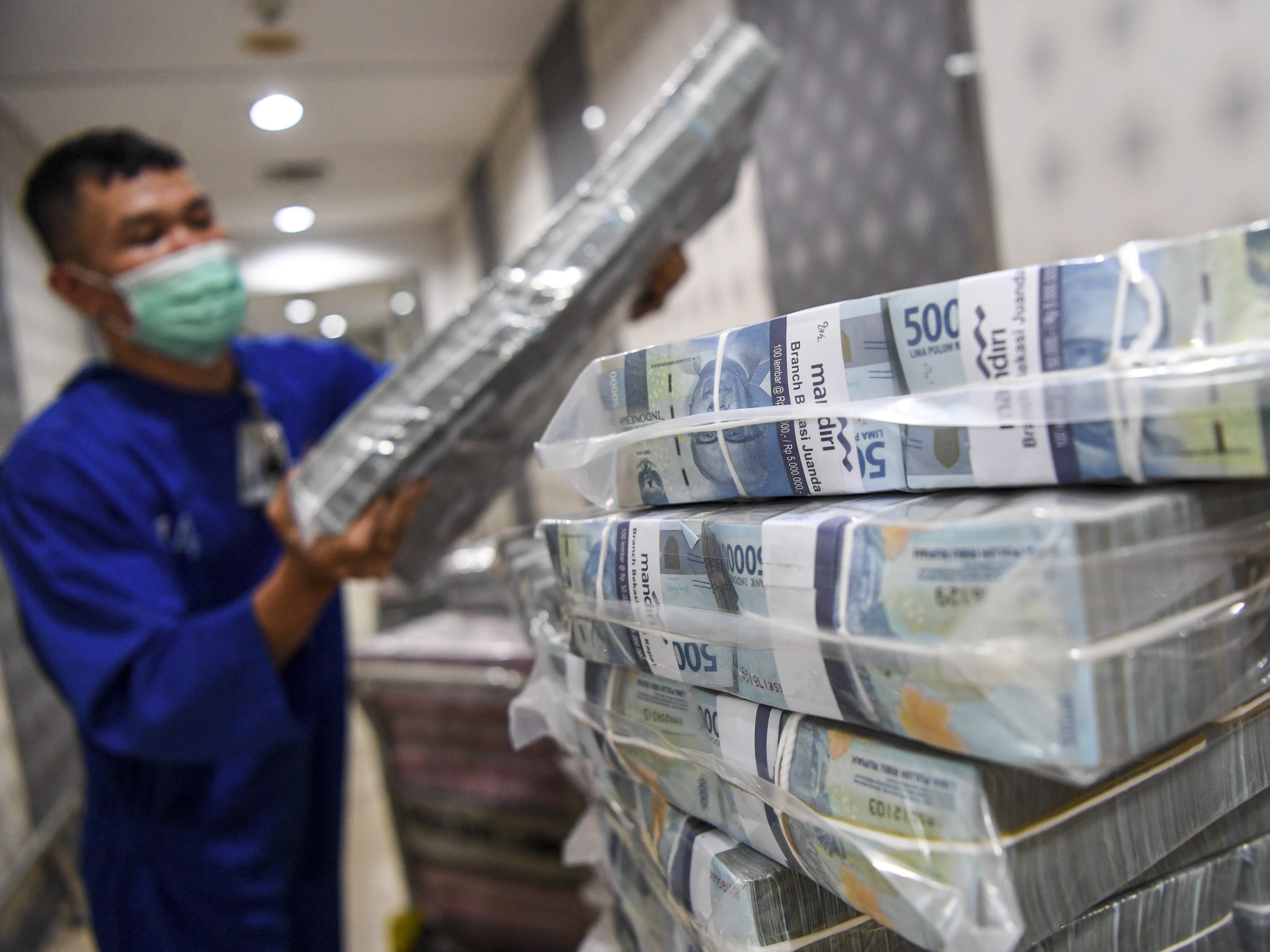 Pegawai menata uang tunai pecahan Rp50 ribu yang akan dikirimkan ke kantor cabang di Sentra Kas Bank Mandiri, Jakarta.