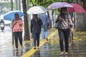  Warga menggunakan payung saat hujan di kawasan Semanggi, Jakarta.  