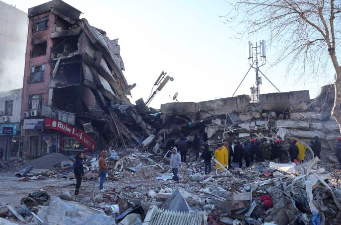 Tim penyelamat dan warga sipil mencari korban selamat di bawah reruntuhan bangunan yang runtuh di Kahramanmaras, Turki selatan.