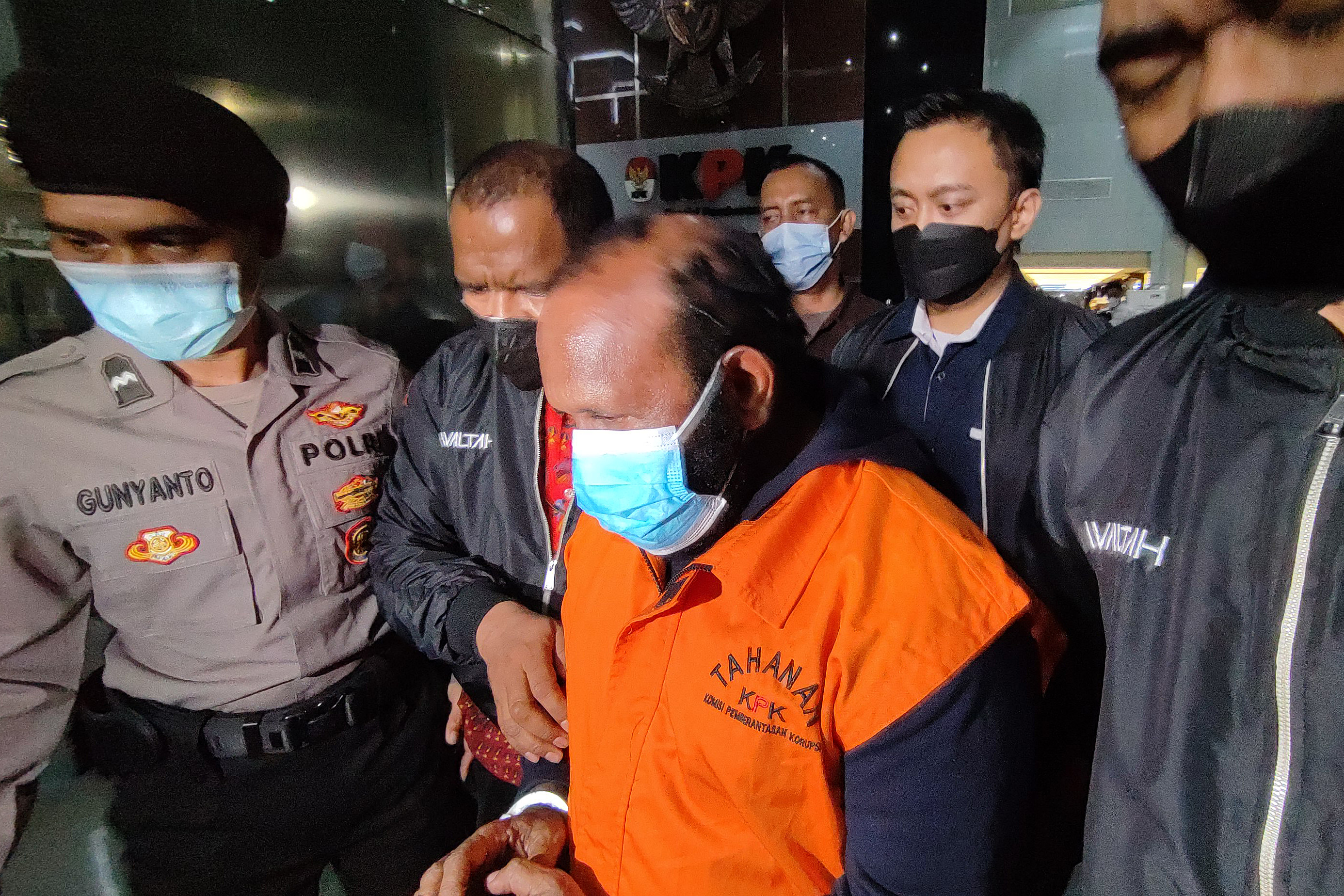 Bupati Mamberamo Tengah nonaktif, Ricky Ham Pagawak mengenakan rompi tahanan dikawal petugas berjalan keluar di Gedung KPK (20/2/2023).