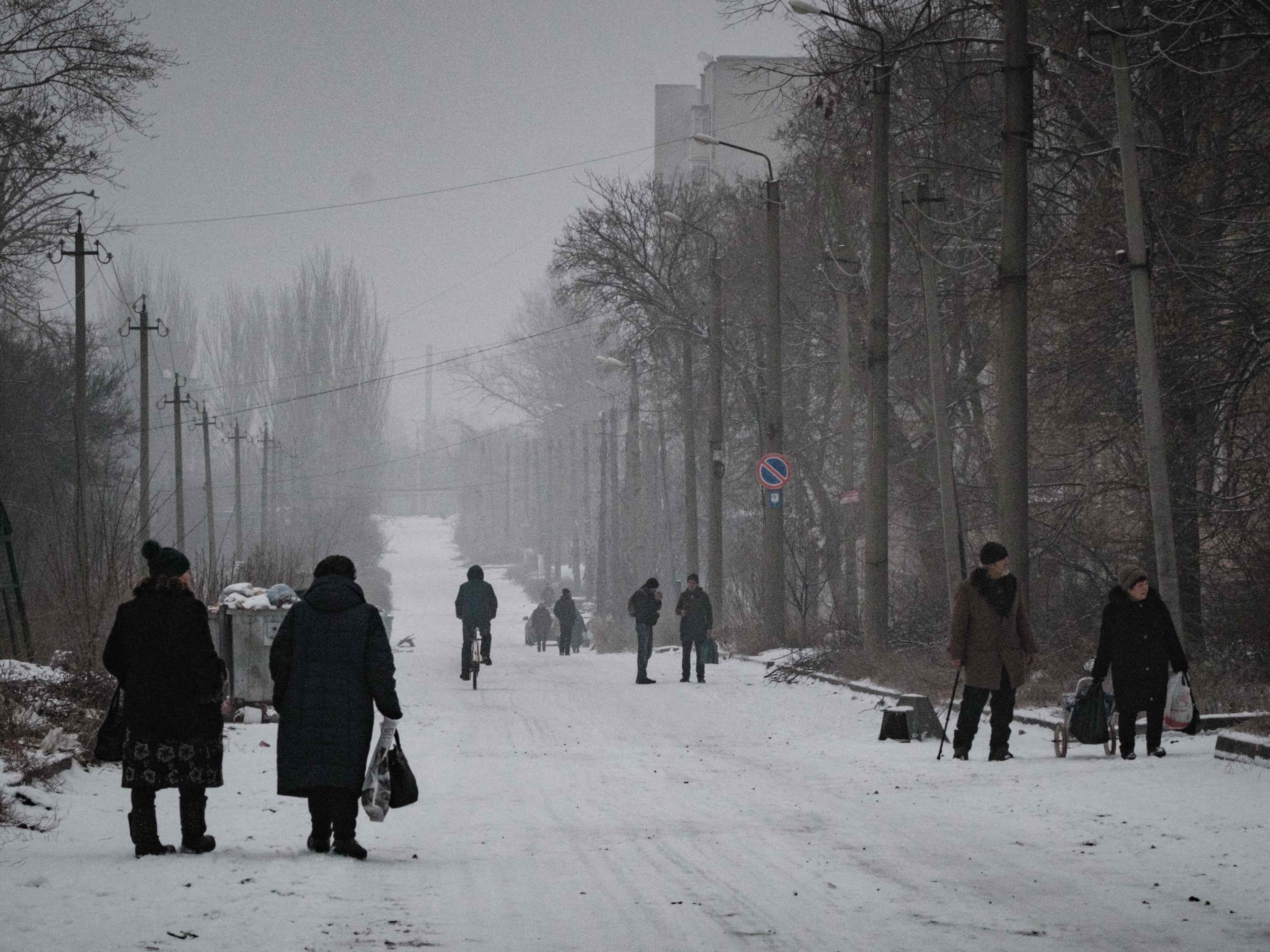 Orang-orang berjalan di sepanjang jalan yang tertutup salju di Bakhmut, di wilayah Donetsk, pada 30 Januari 2023.