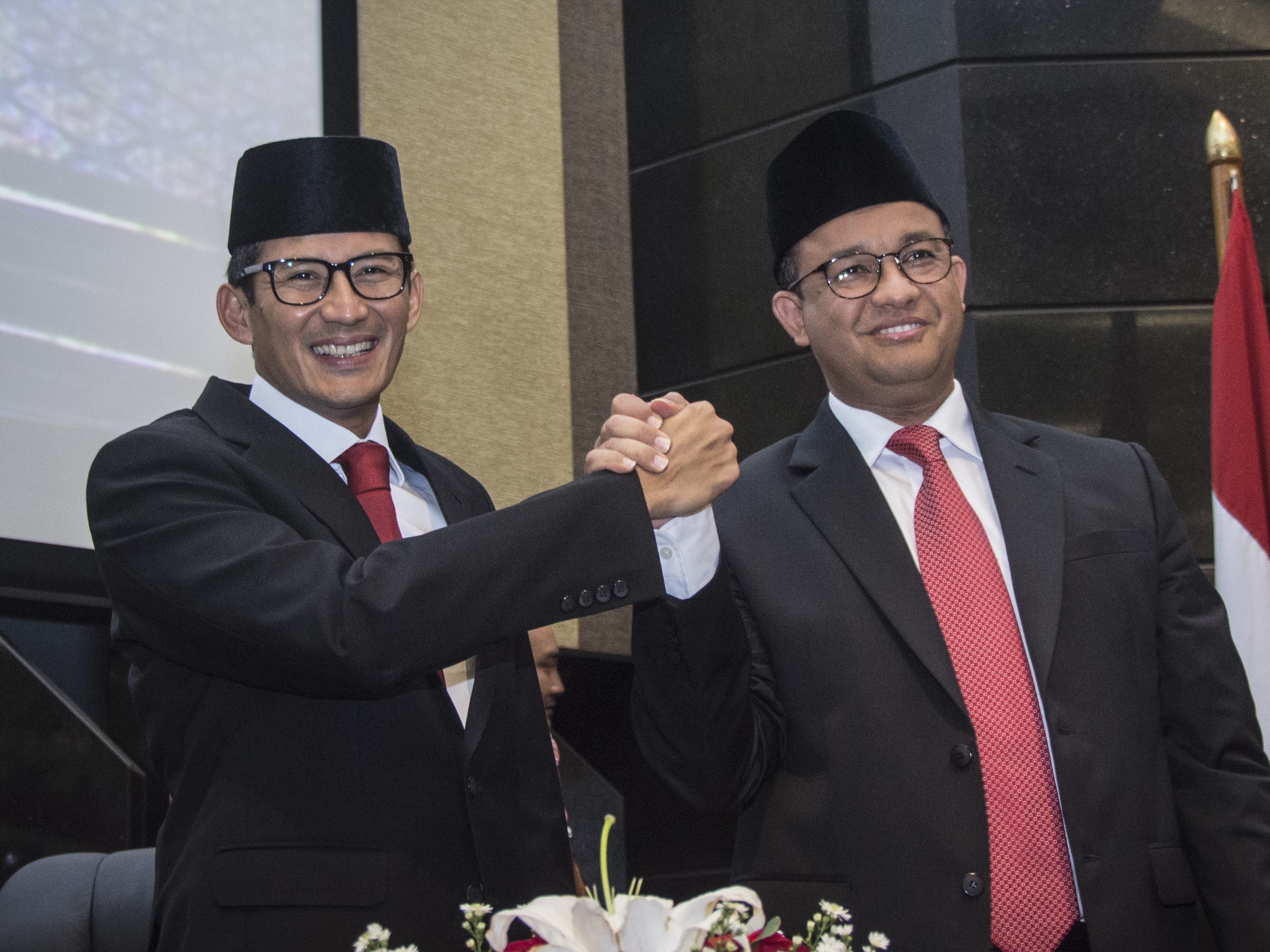 Gubernur DKI Jakarta Anies Baswedan (kanan) berjabat tangan dengan Wakil Gubernur Sandiaga Uno (kiri) pada November 2017.