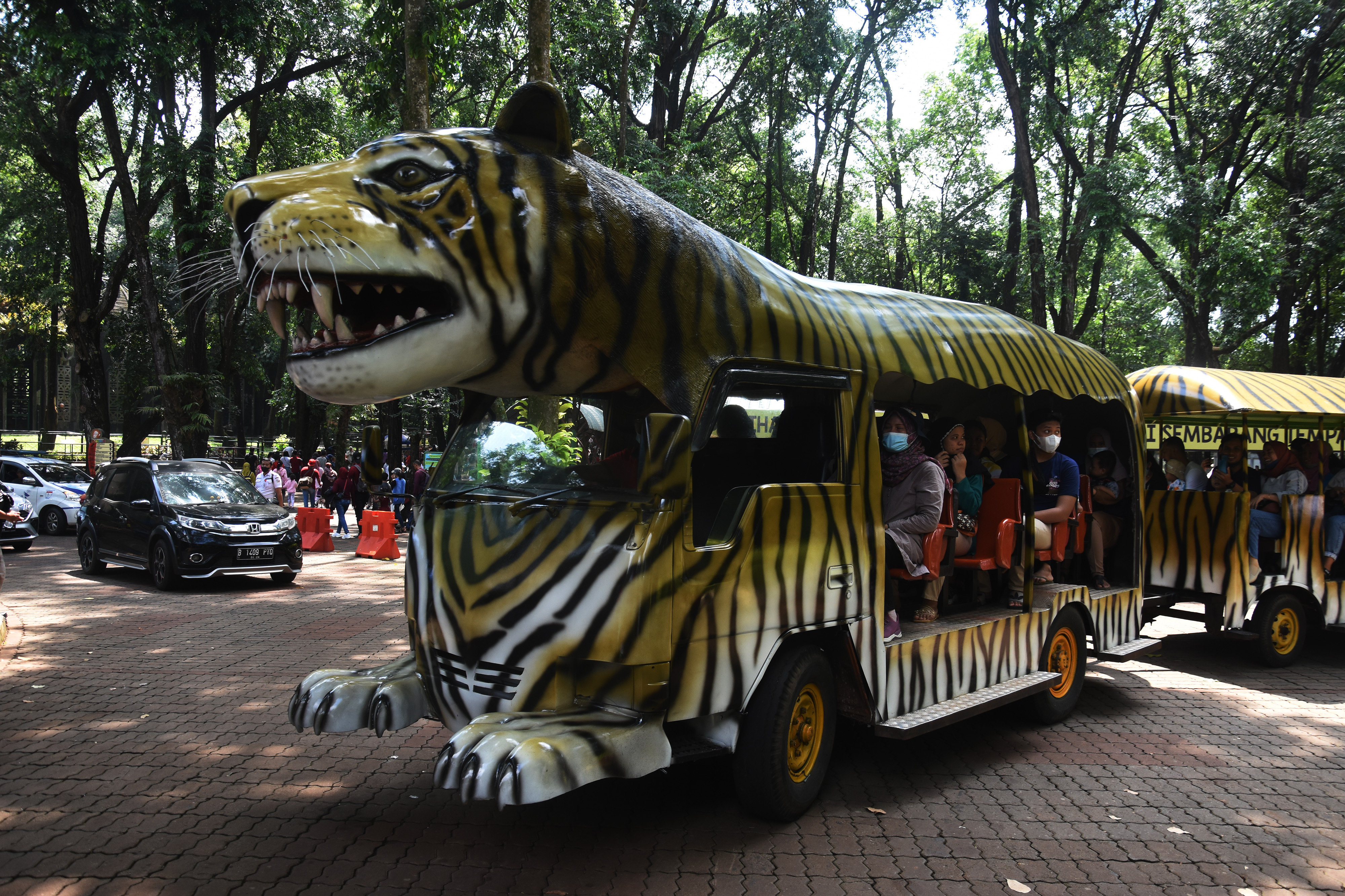 Warga menaiki mobil wisata saat mengunjungi Taman Margasatwa Ragunan di Jakarta.