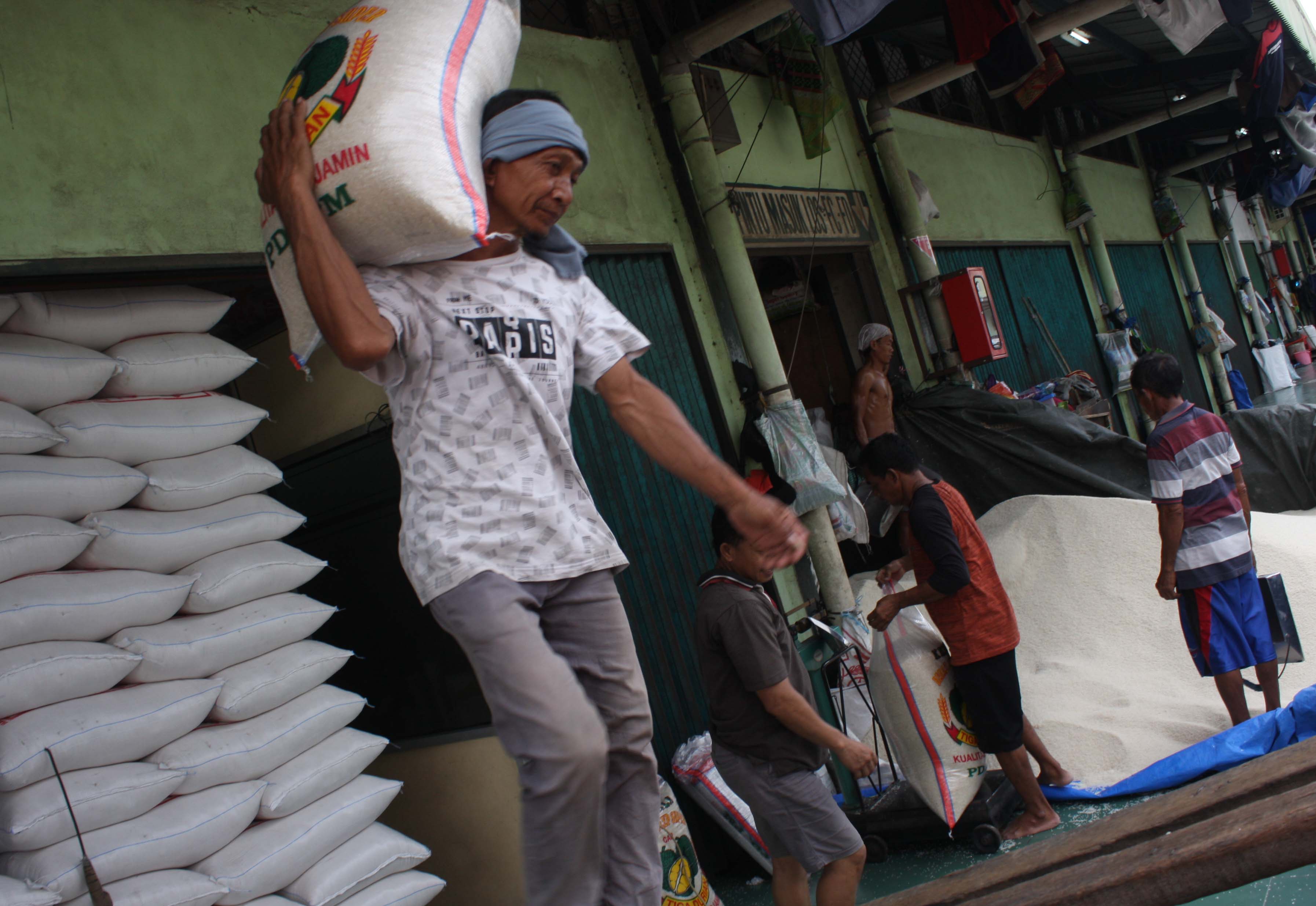 Pekerja melakukan pengepakan beras di Pasar Cipinang, Jakarta. 