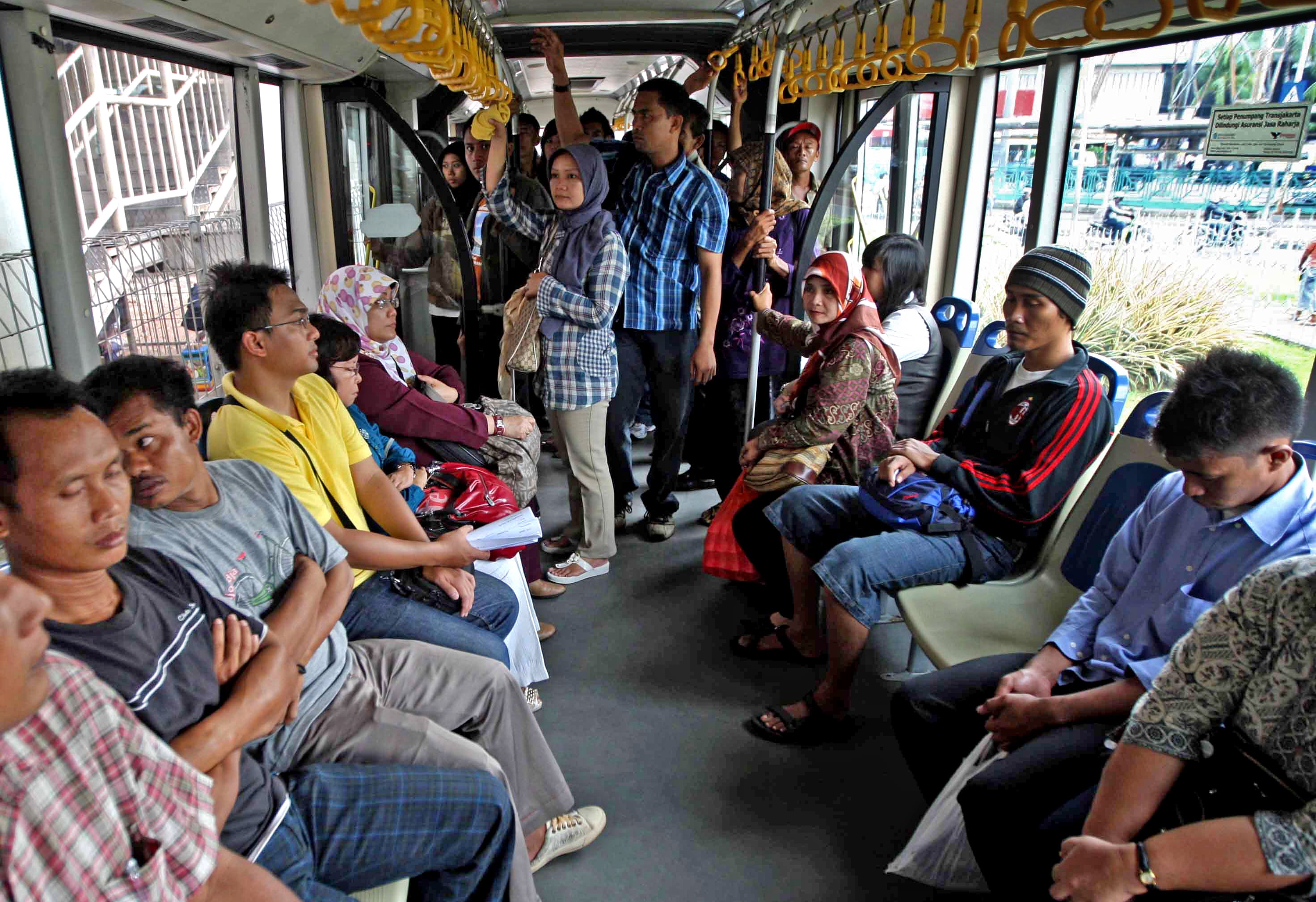 Ilustrasi: penumpang Pria dan wanita Bus Transjakarta ketika didalam bus gandeng jurusan Senen-Ancol.