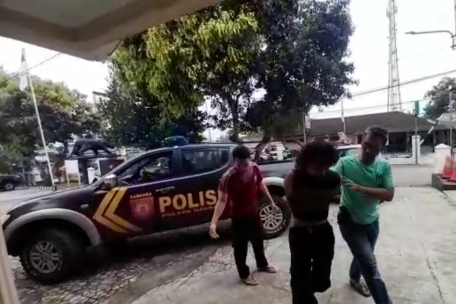 Polisi membawa pelaku penusukan.