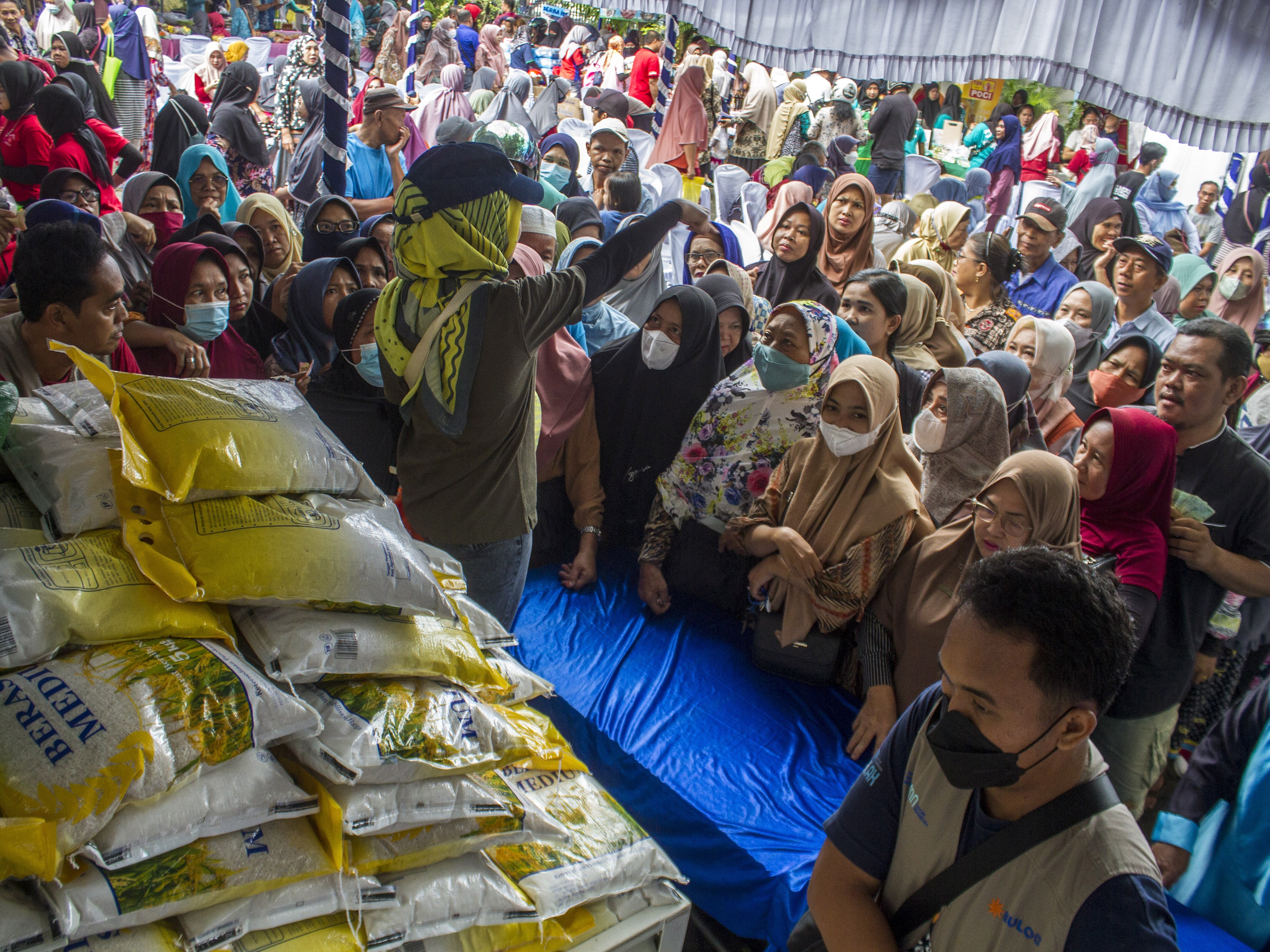 Petugas mengatur antrean warga yang hendak membeli beras murah seharga Rp45.000 per kemasan 5 kilogram saat pasar murah di Banjarmasin.
