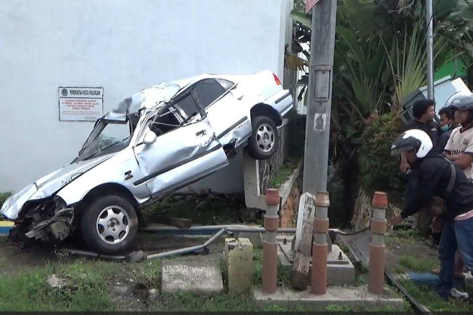Mobil yang tersangkut pagar.