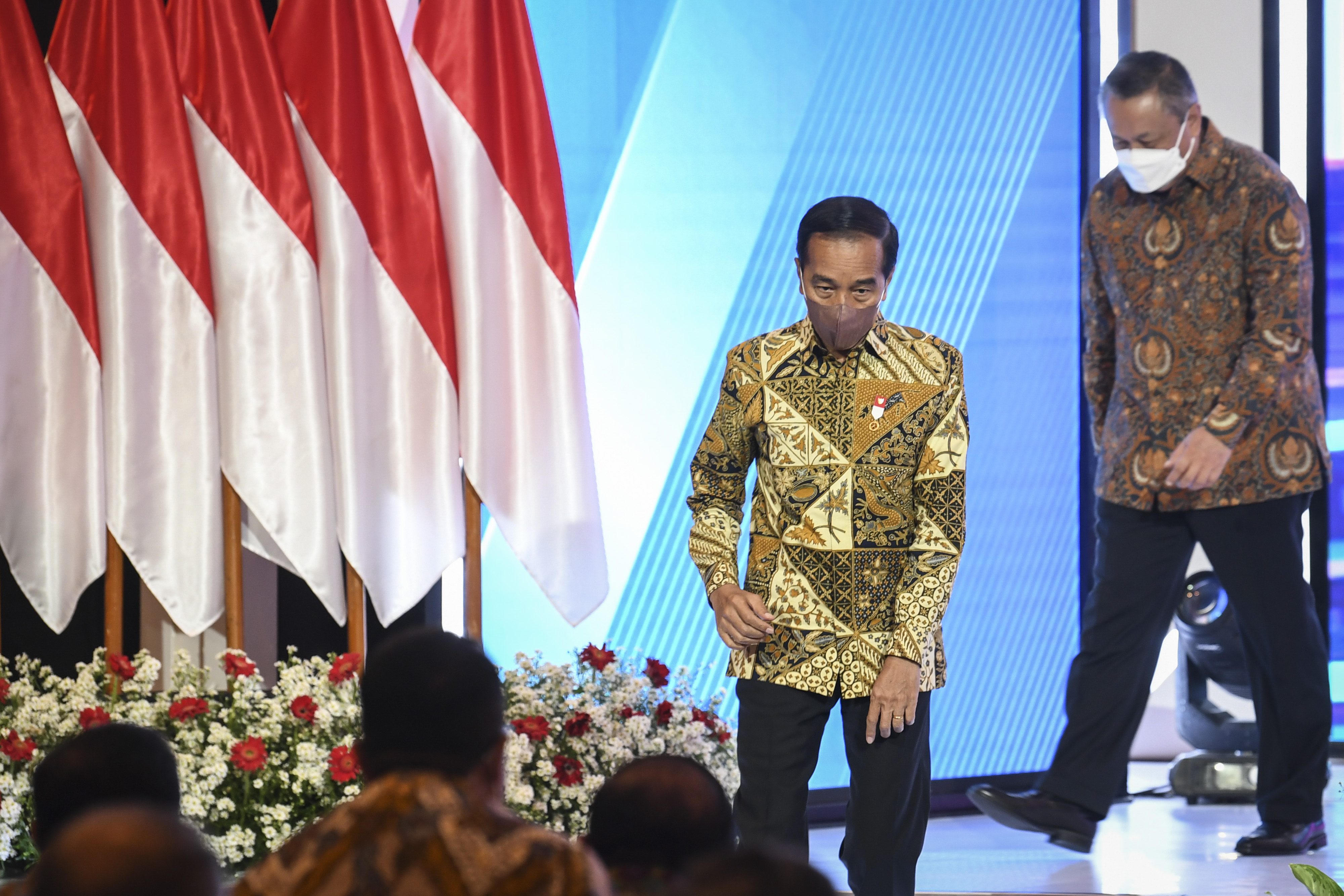 Presiden Jokowi didampingi Gubernur BI Perry Warjiyo berjalan seusai memberikan sambutan.