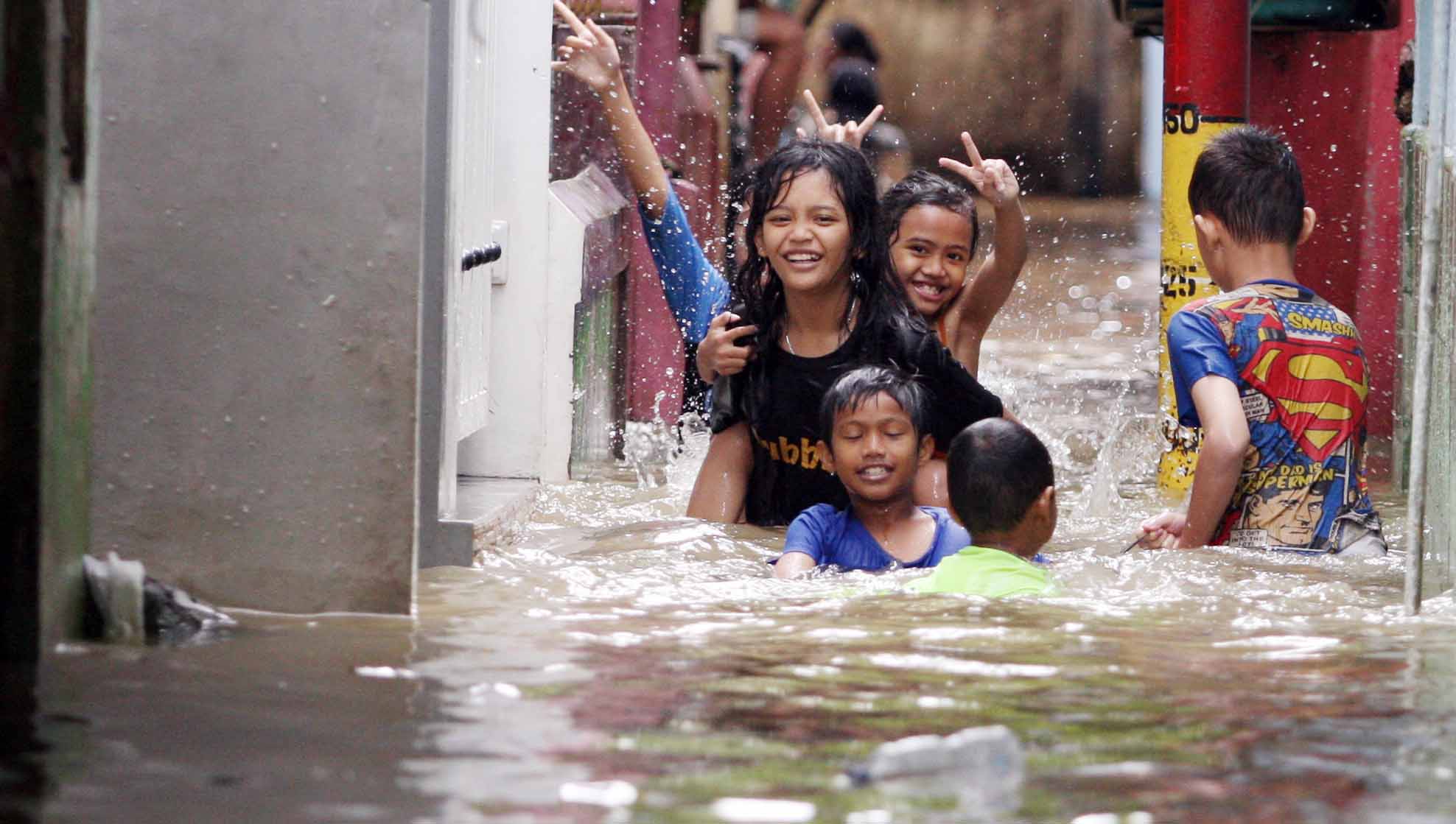 Anak-anak bermain di tengah banjir yang merendam kawasan Kebon Pala, Kecamatan Jatinegara, Jakarta Timur, Senin (27/02/2023). 