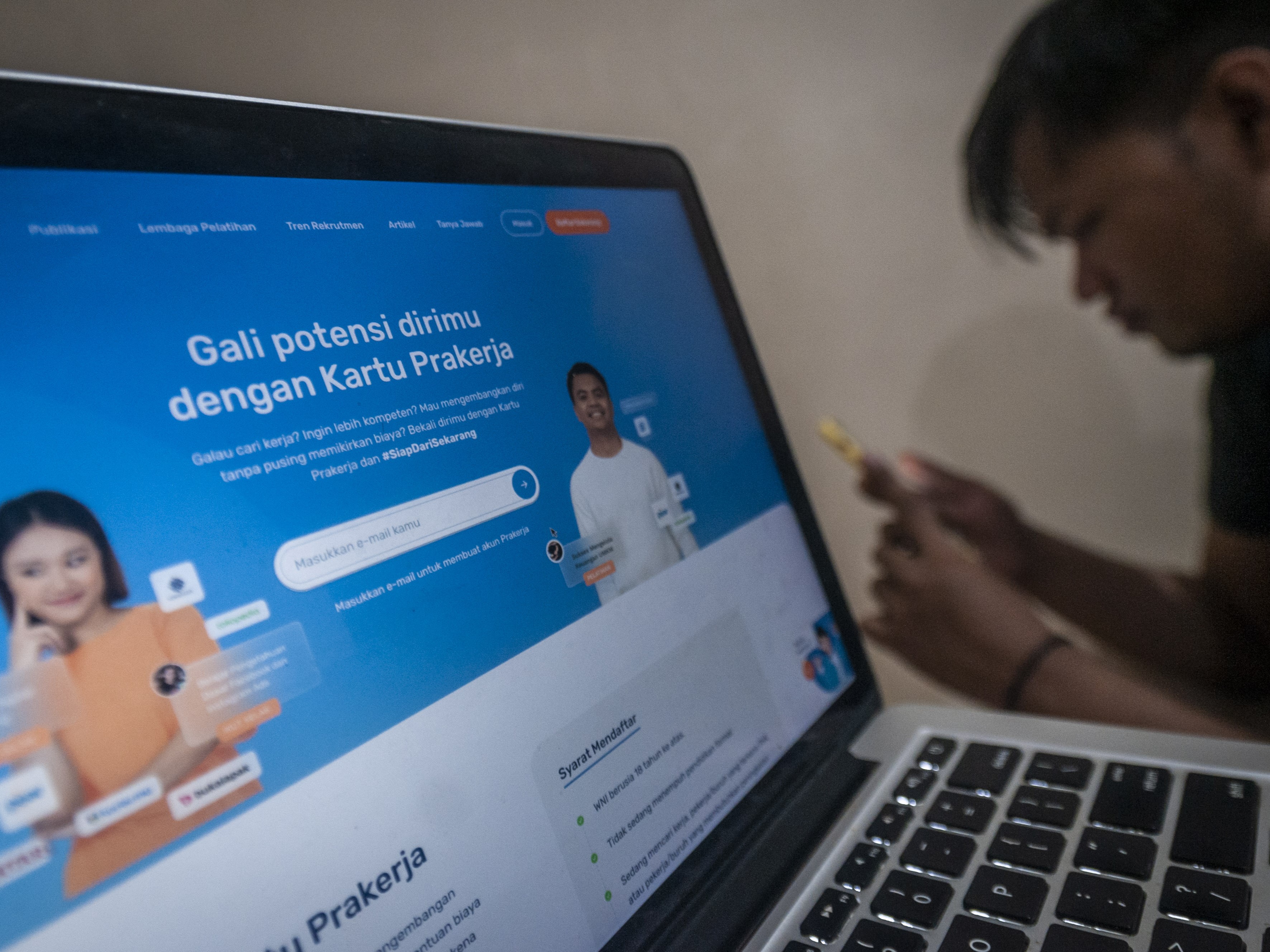 Seorang warga mengakses laman situs Prakerja di Rangkasbitung, Lebak, Banten.