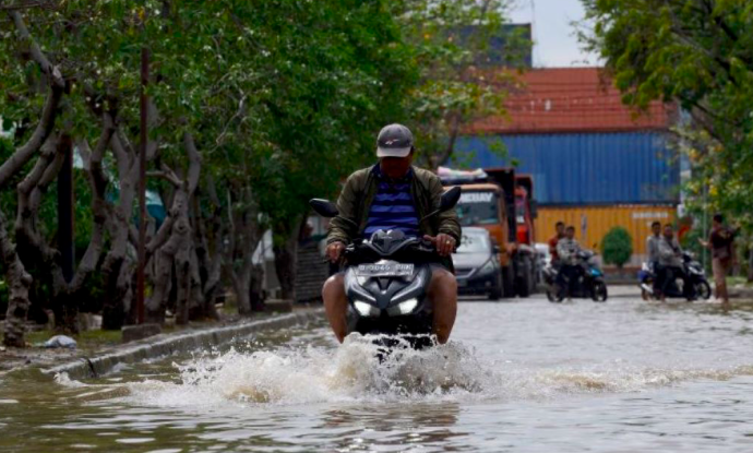 Ilustrasi warga melintasi jalan yang tergenang. 