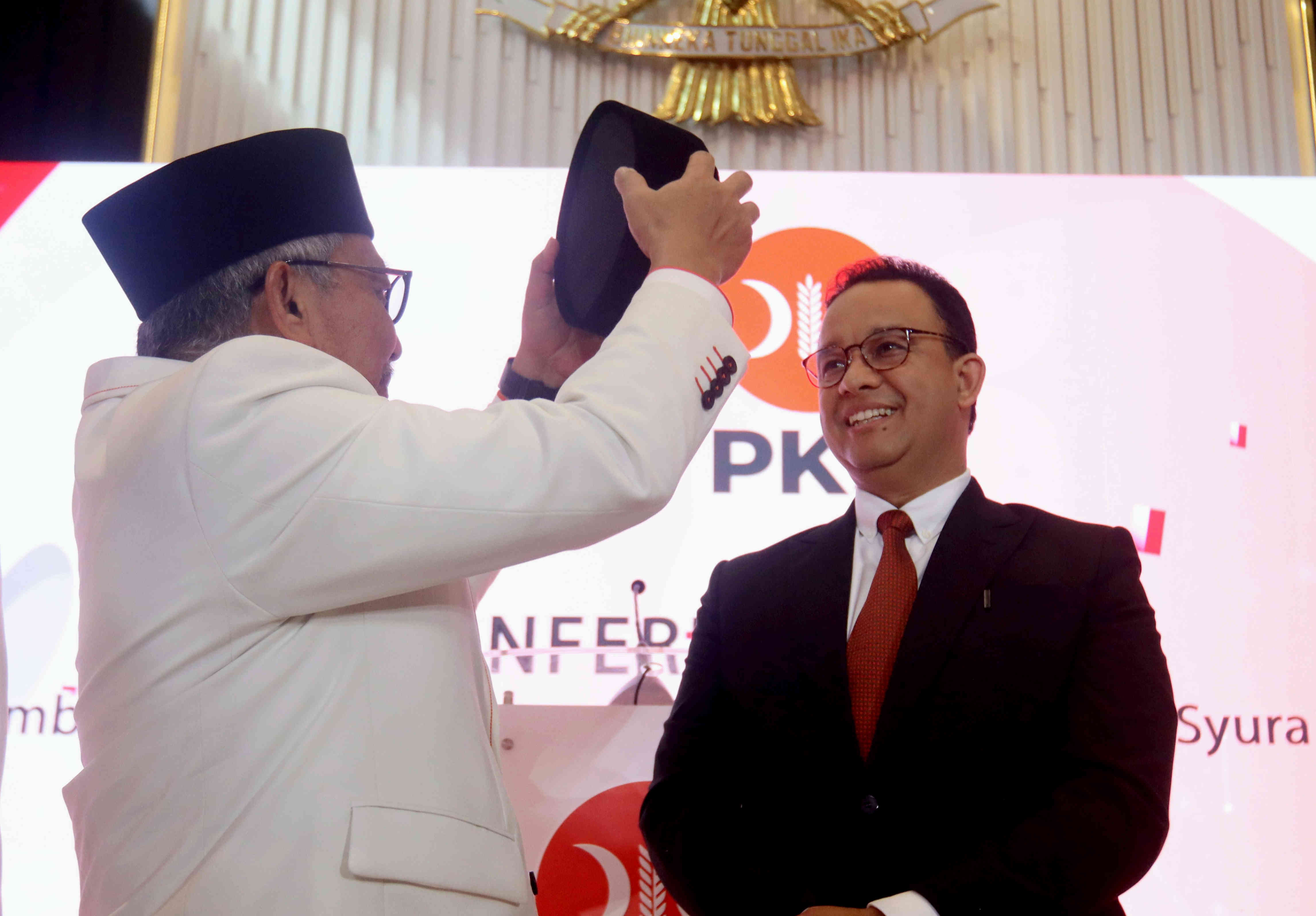 Presiden PKS Ahmad Syaikhu (kiri) menyematkan peci kepada Bakal Calon Presiden Partai NasDem Anies Baswedan (kanan)