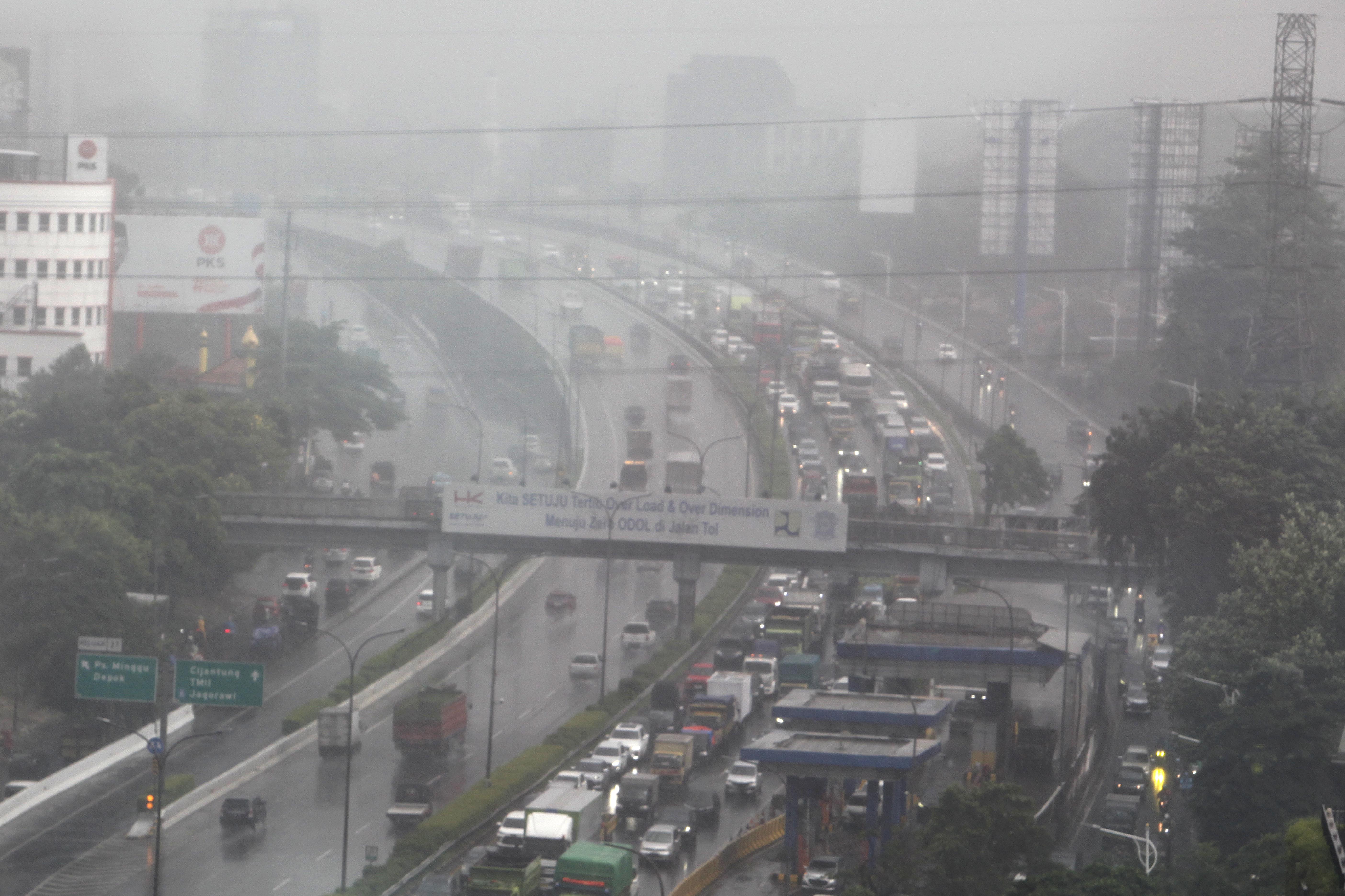  Kendaraan berjalan perlahan akibat hujan disertai angin kencang melanda kawasan Jakarta, beberapa waktu lalu.
