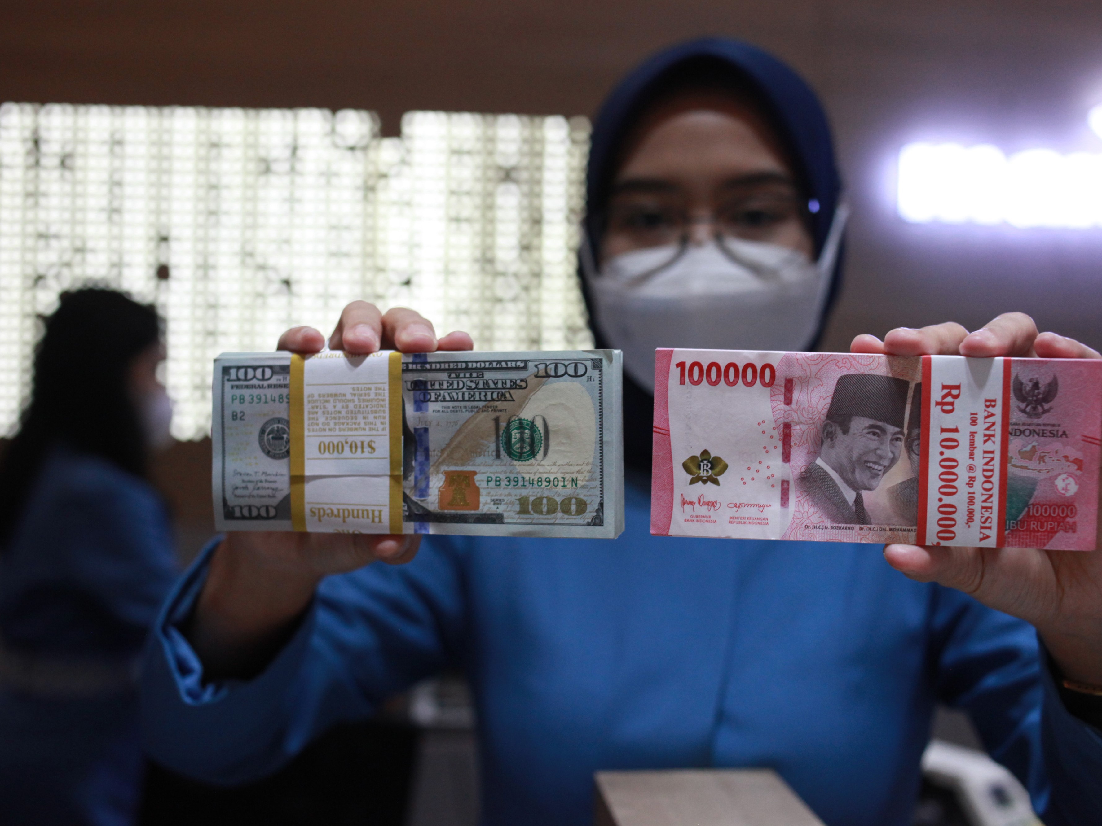 Petugas menunjukkan uang dolar AS dan uang rupiah di salah satu kantor cabang PT. Bank Mandiri Persero Tbk, Jakarta, Selasa (31/1/2023).