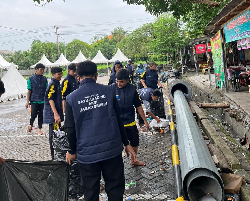 Pergerakan Mahasiswa Islam Indonesia (PMII) Ciputat membersihkan sampah dari perayaan satu abad NU di Gelora Delta Sidoarjo, Selasa (7/2)