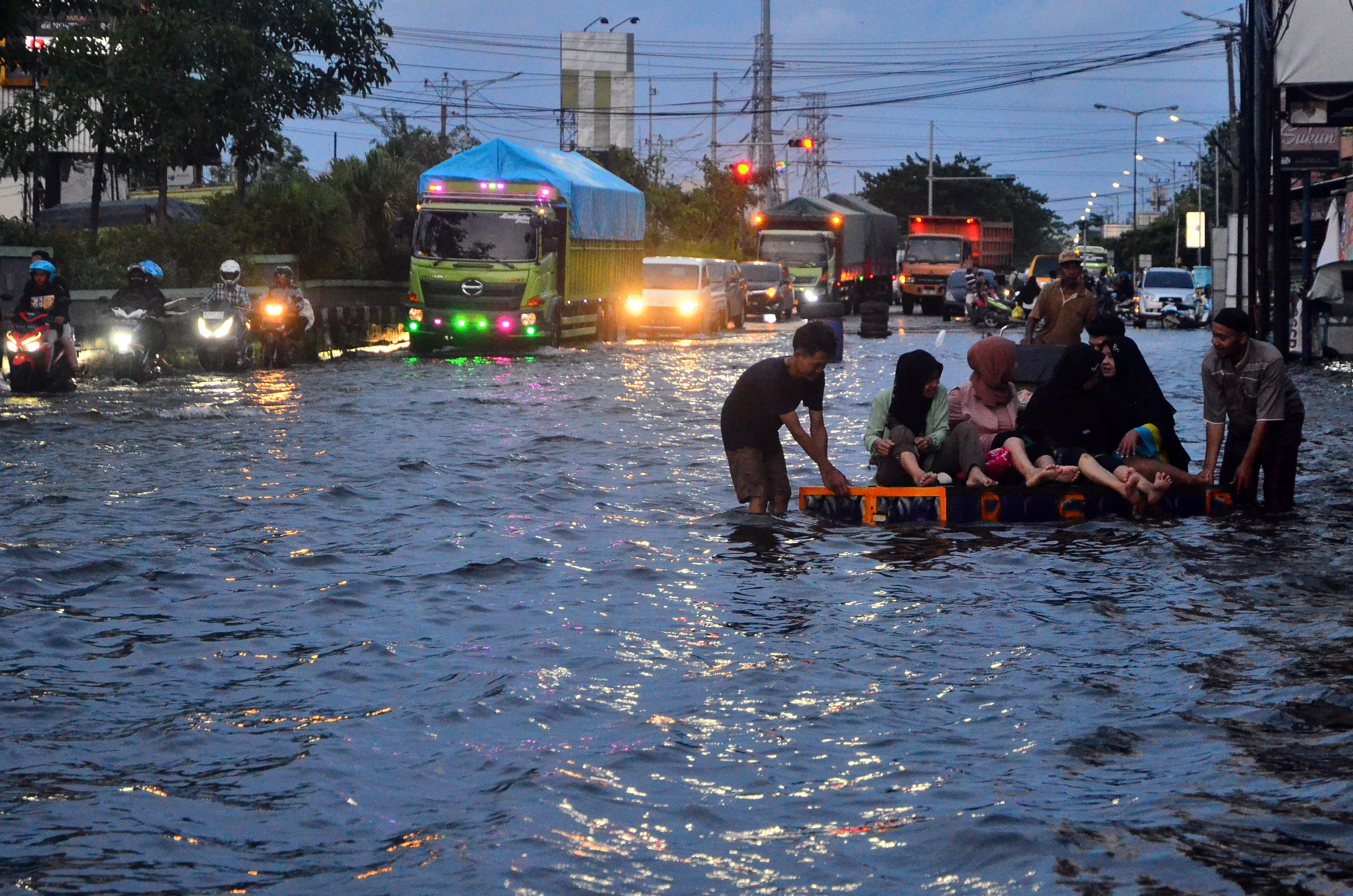 Sejumlah kendaraan menerobos jalan yang tergenang banjir di jalan nasional jalur Pantura (Pantai Utara) Desa Jati Wetan, Kudus, Jawa Tengah