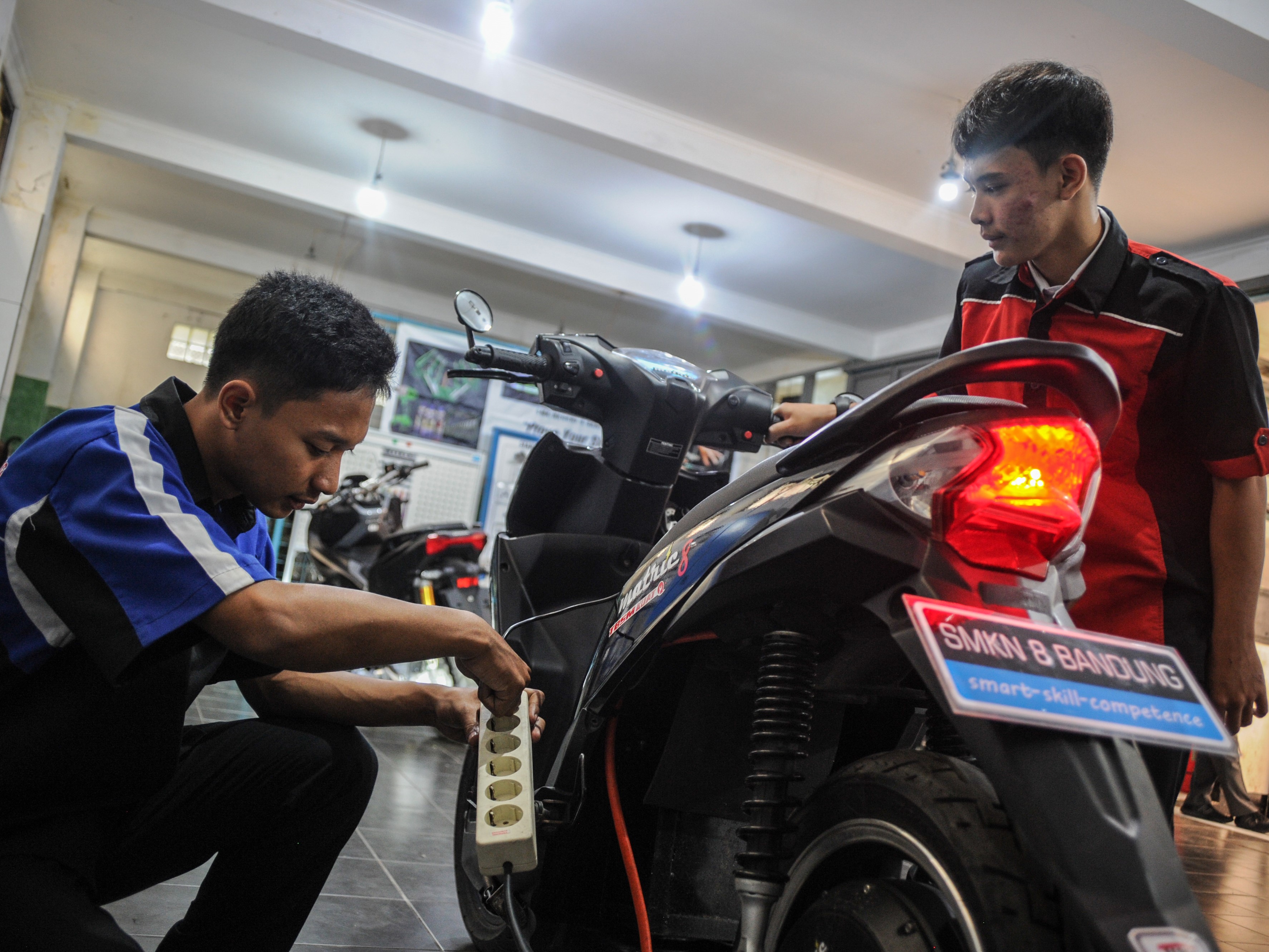 Siswa SMK melakukan perawatan motor berbahan bakar minyak yang telah dikonversikan ke listrik di SMKN 8 Bandung, Jawa Barat.