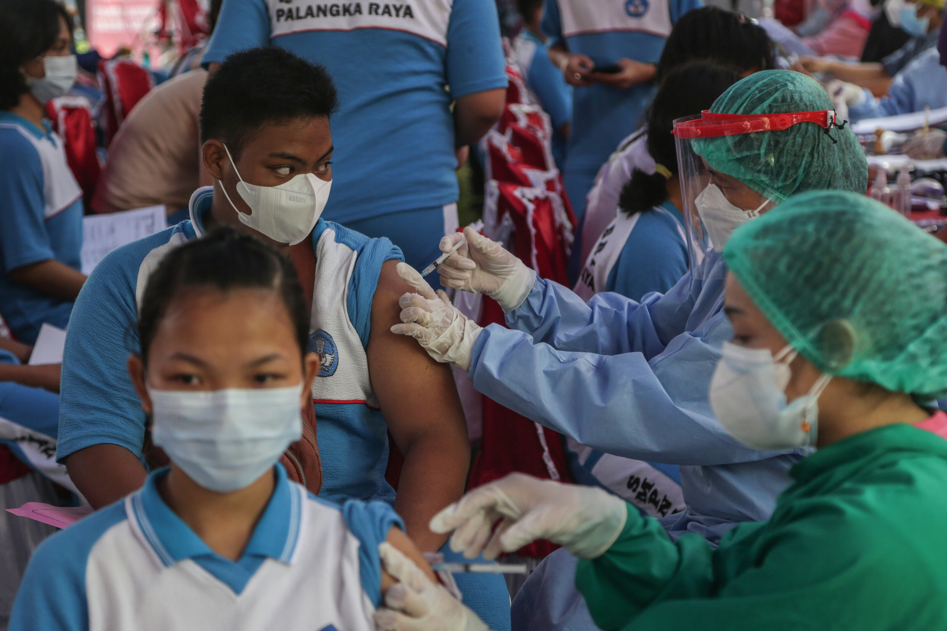 Petugas medis menyuntikkan vaksin covid-19 kepada siswa SMP.