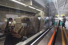 Penumpang menunggu jadwal keberangkatan kereta api di Stasiun Gubeng, Surabaya.  