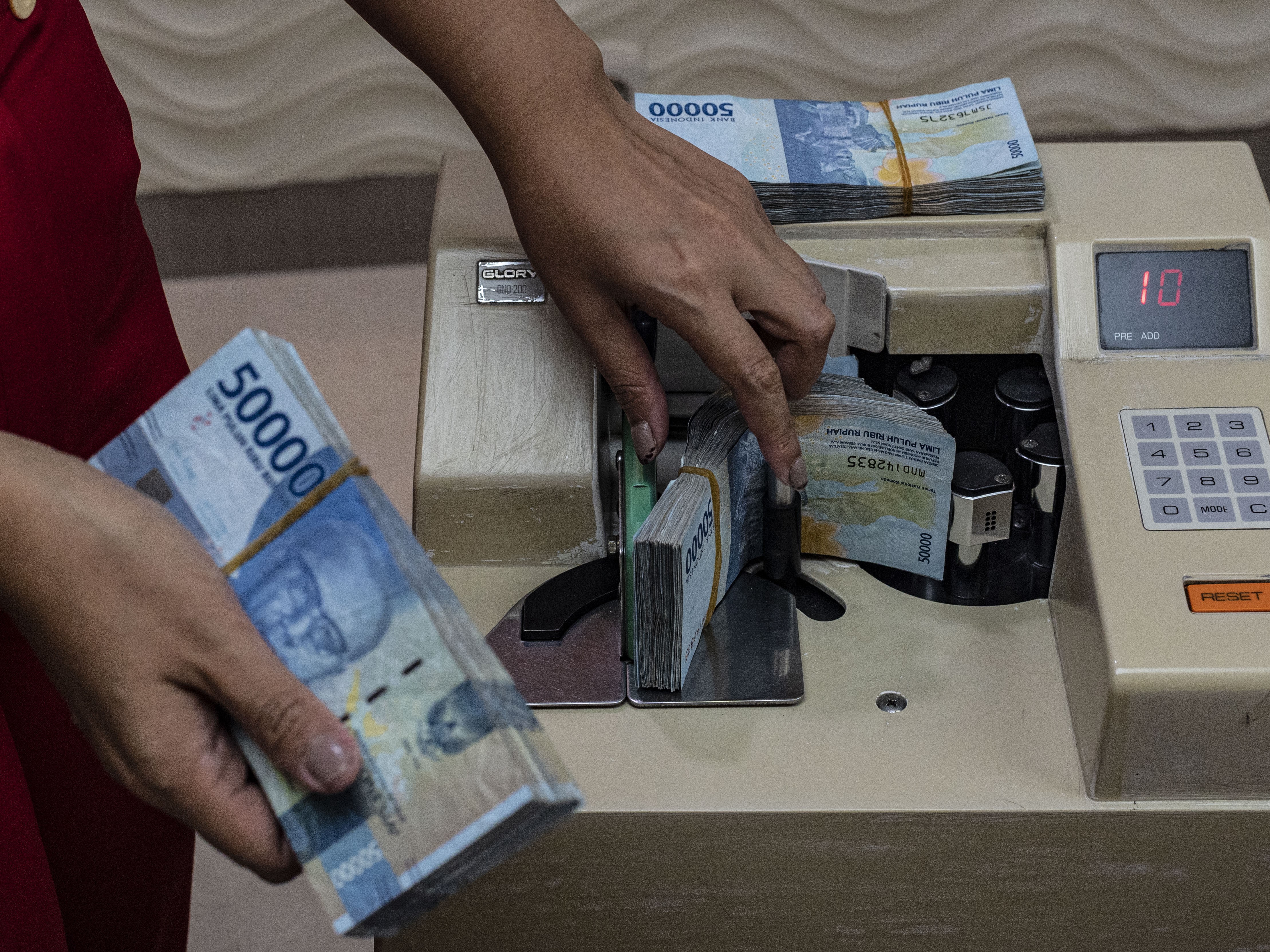 Pegawai menghitung uang rupiah di salah satu tempat penukaran uang di Jakarta.