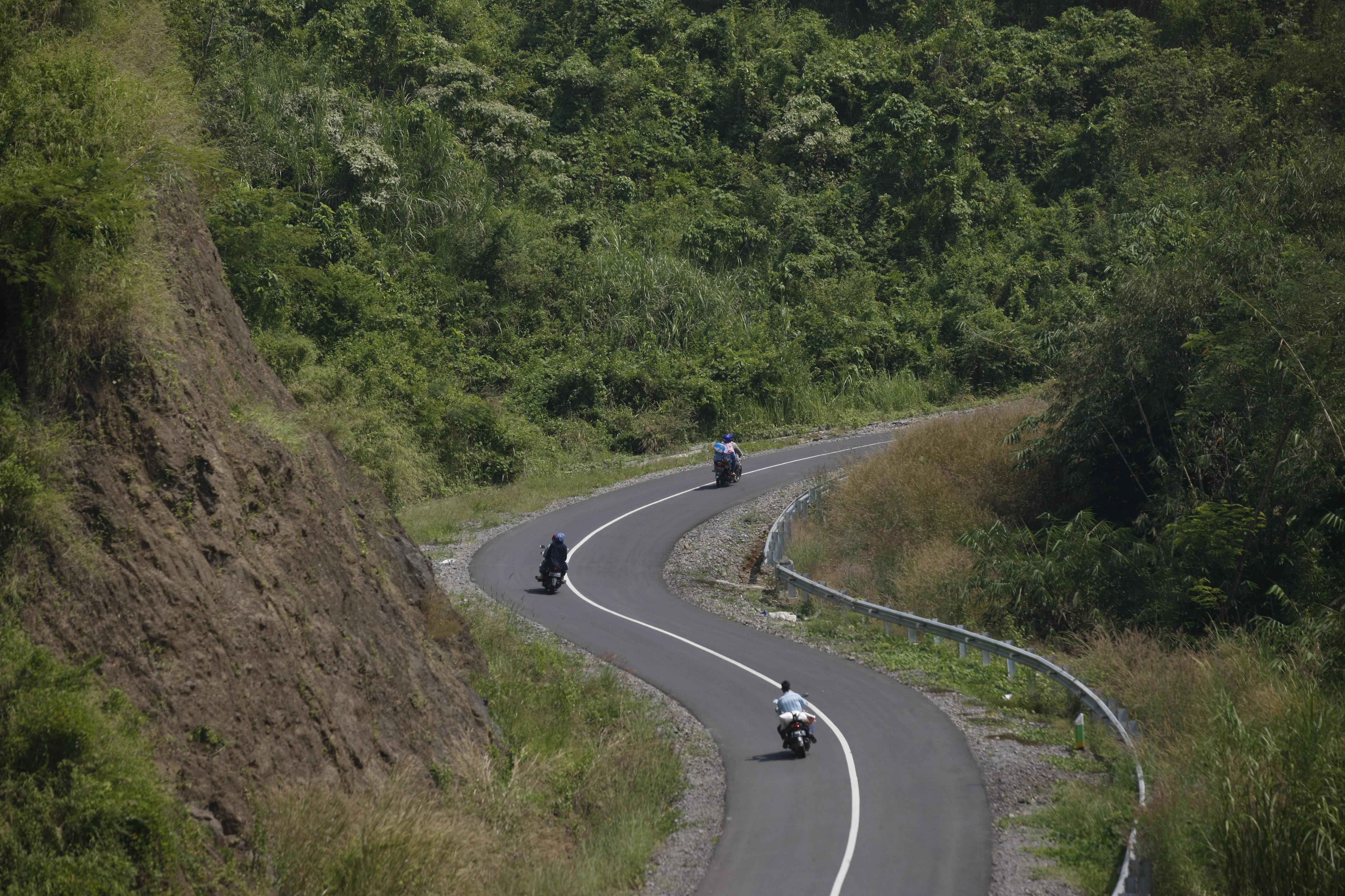 Kendaraan melintasi jalan berkelok di jalur selatan Jawa.