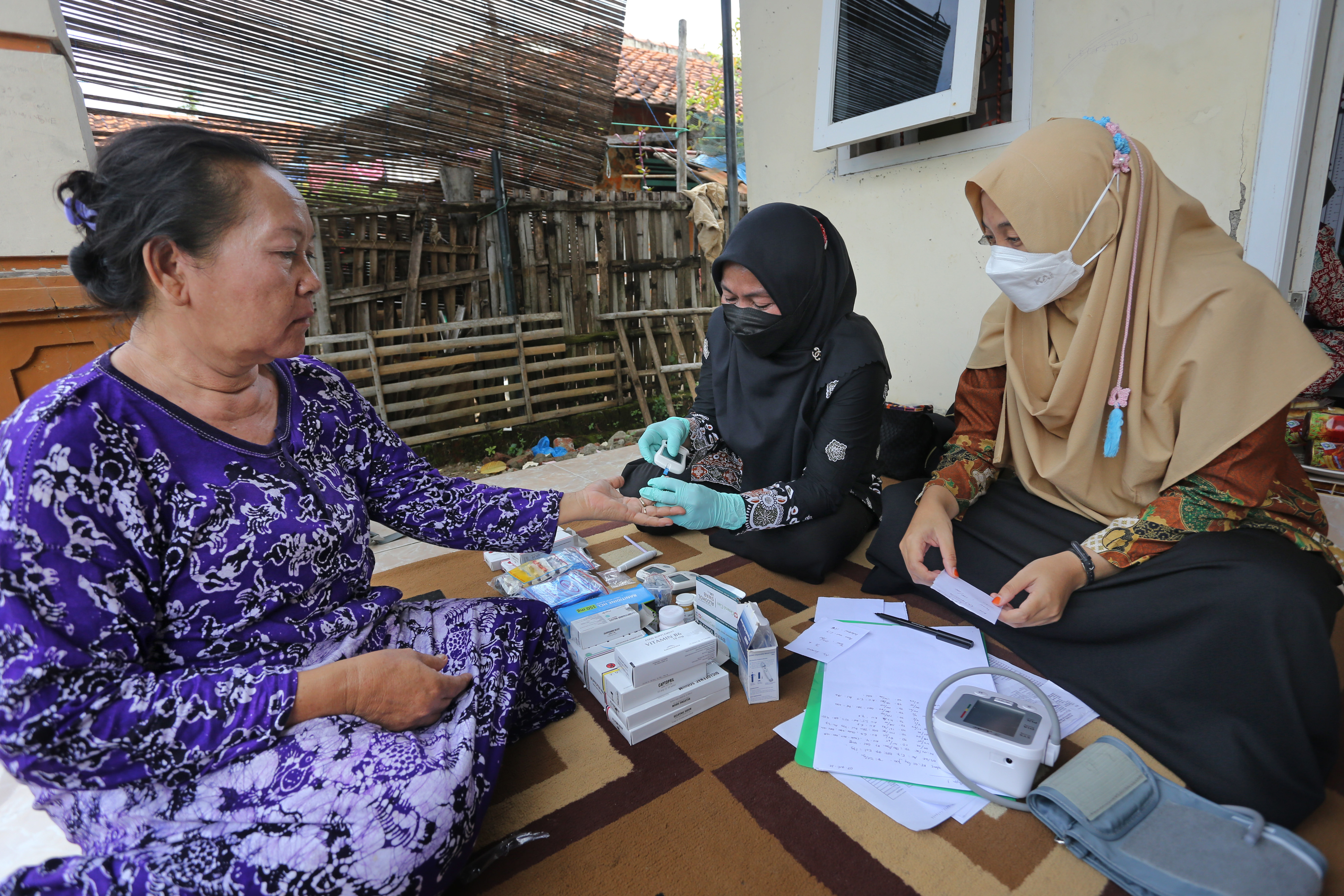Petugas kesehatan dari Puskesmas Margadadi mengambil sampel darah lansia untuk mengukur kadar gula darah di Posyandu Karangmulya.