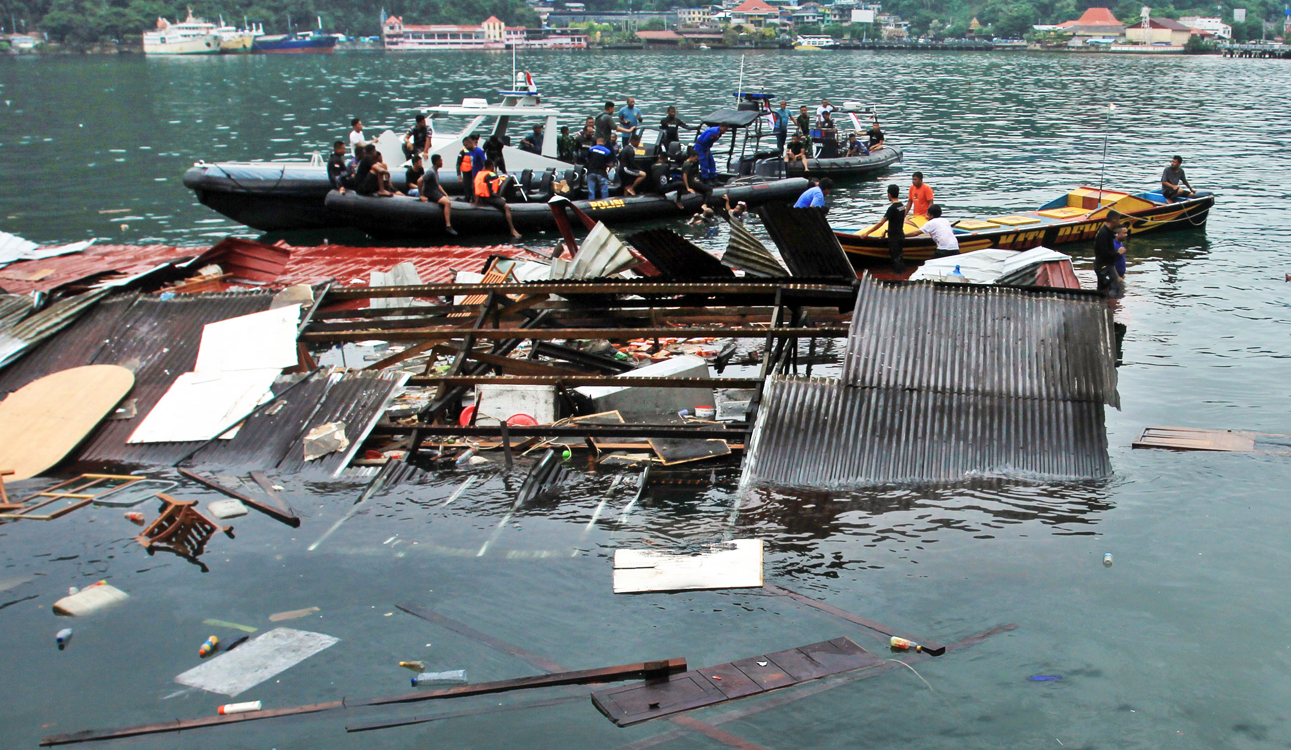 Sejumlah polisi mencari korban di reruntuhan bangunan rumah makan yang tenggelam akibat gempa bumi di Jayapura, Papua, Kamis (9/2/2023).