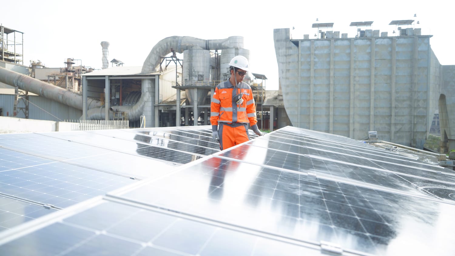 Seorang karyawan Semen Gresik tengah memeriksa kondisi pembangkit listrik tenaga surya 