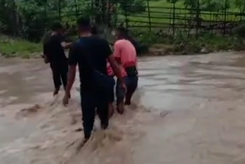Warga Kupang melintasi banjir.