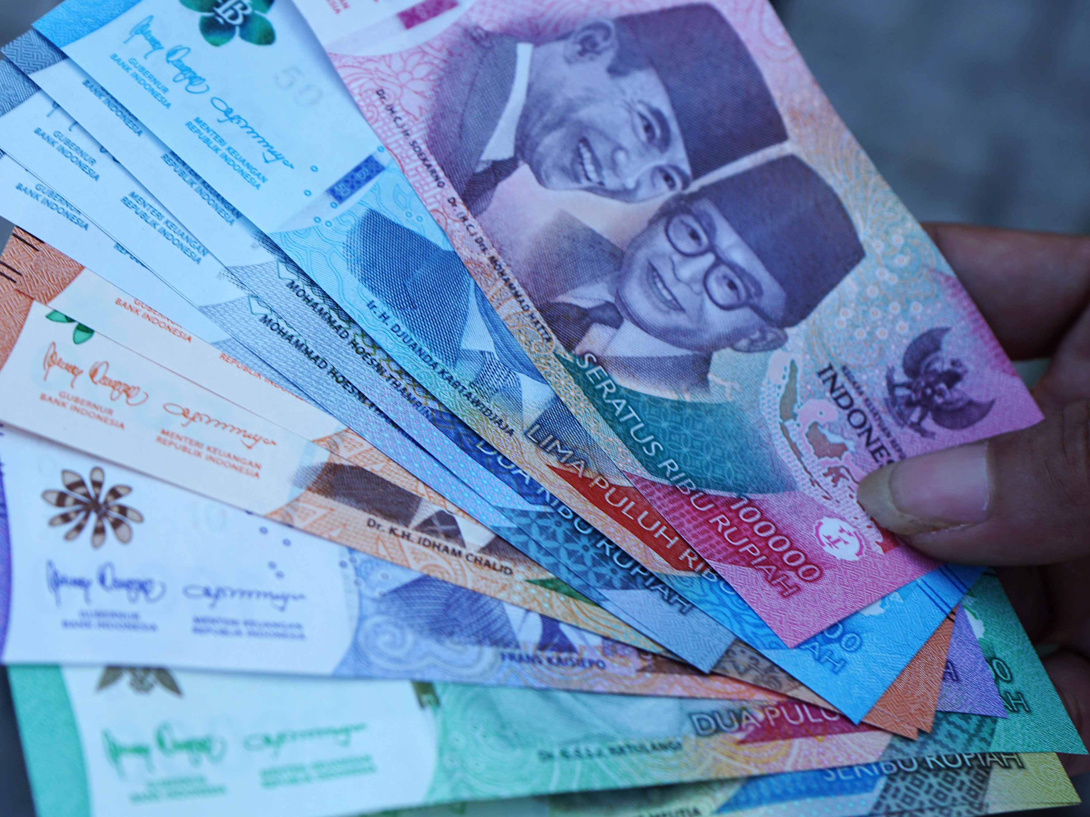 Seorang warga menunjukkan uang rupiah kertas Tahun Emisi 2022.