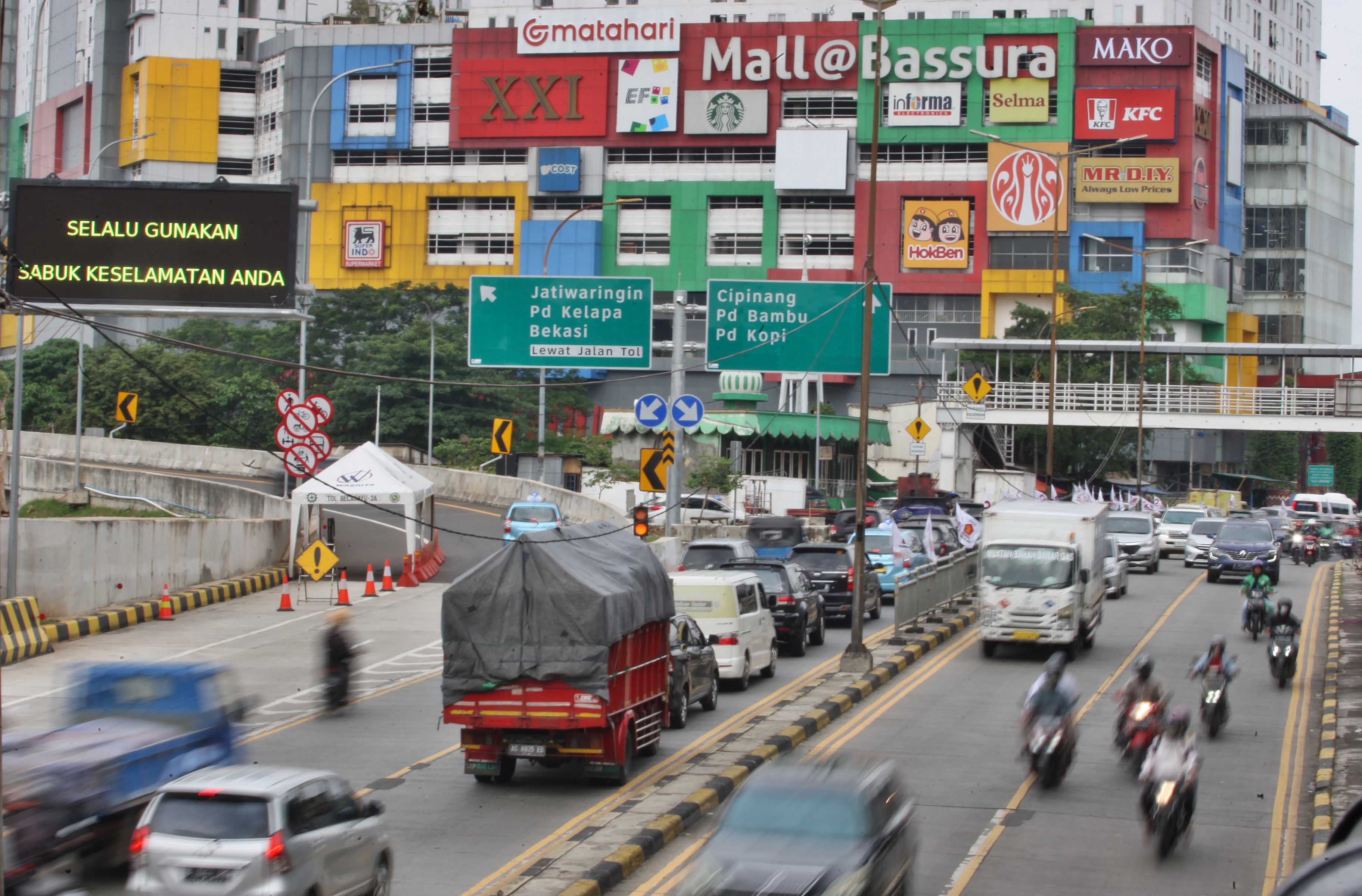 Mobilitas kendaraan dengan latar belakang pusat perbelanjaan di Jakarta.