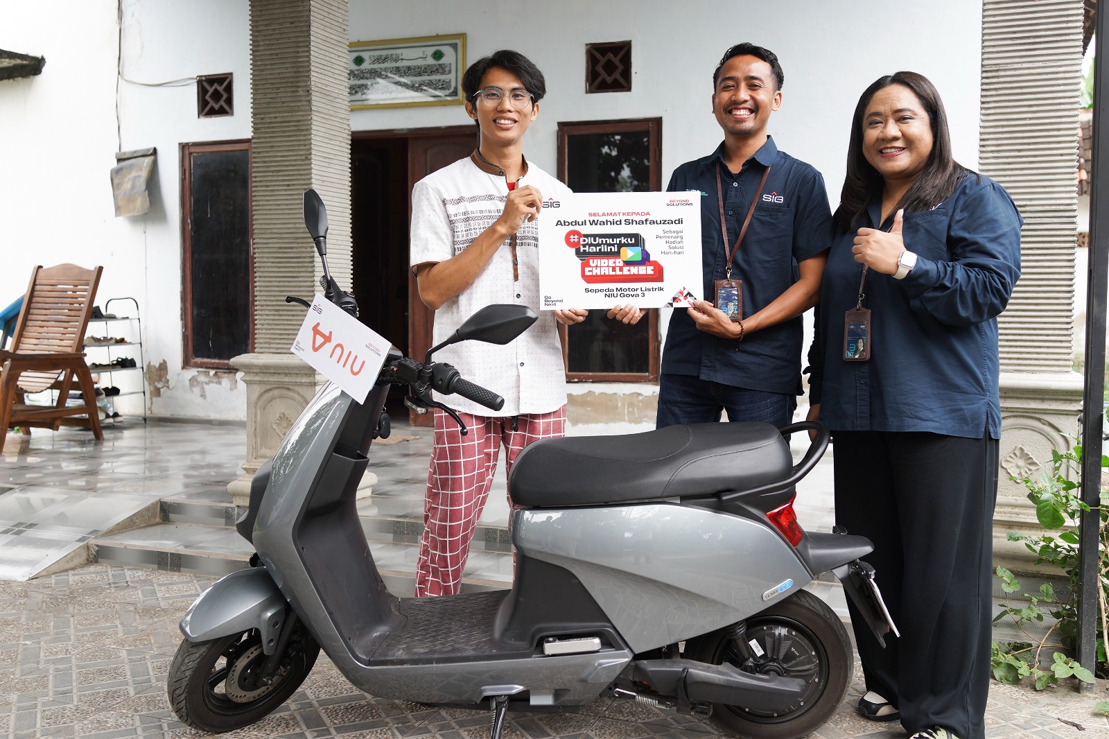 Firman Bahari (kedua kanan), Corporate Communication SIG, menyerahkan hadiah Motor Listrik NIU Gova 03 kepada Abdul Wahid, pemenang lomba.