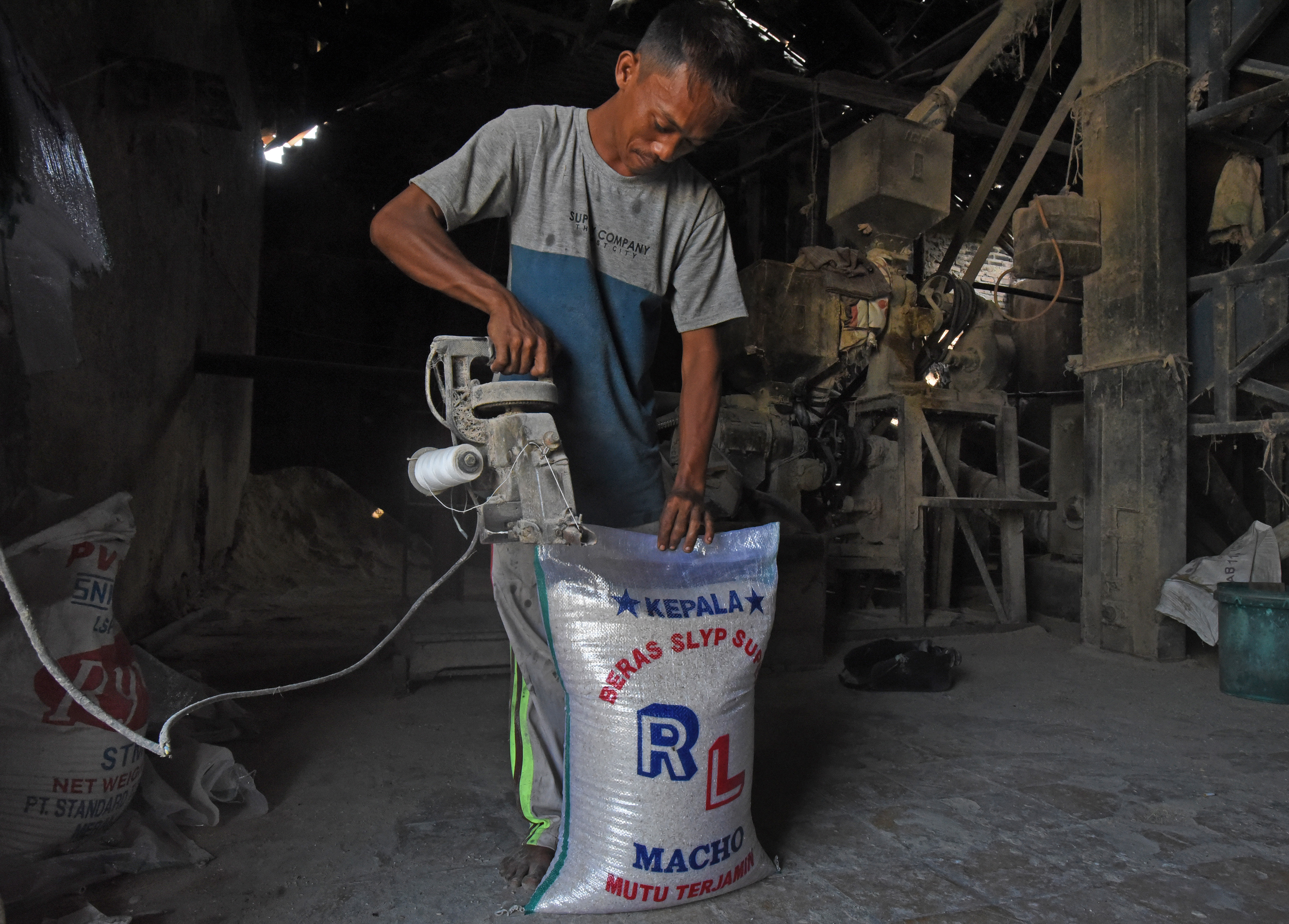 Pekerja menjahit kemasan beras di penggilingan padi Kampung Kubang Mas, Kecamatan Warungjaud, Serang, Banten, Senin (1/8/2022). 