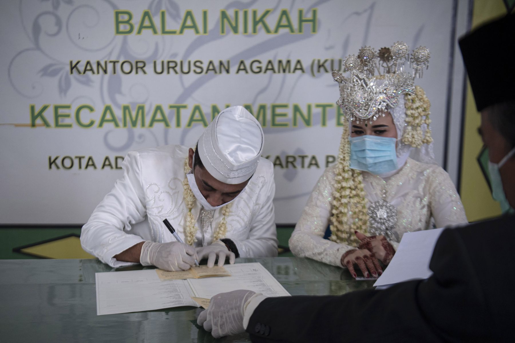 Pasangan pengantin Novi Herdjanto (kiri) dan Mellawati Isnoer menandatangani buku nikah seusai akad nikah di KUA Kec. Menteng Jakarta (11/4)