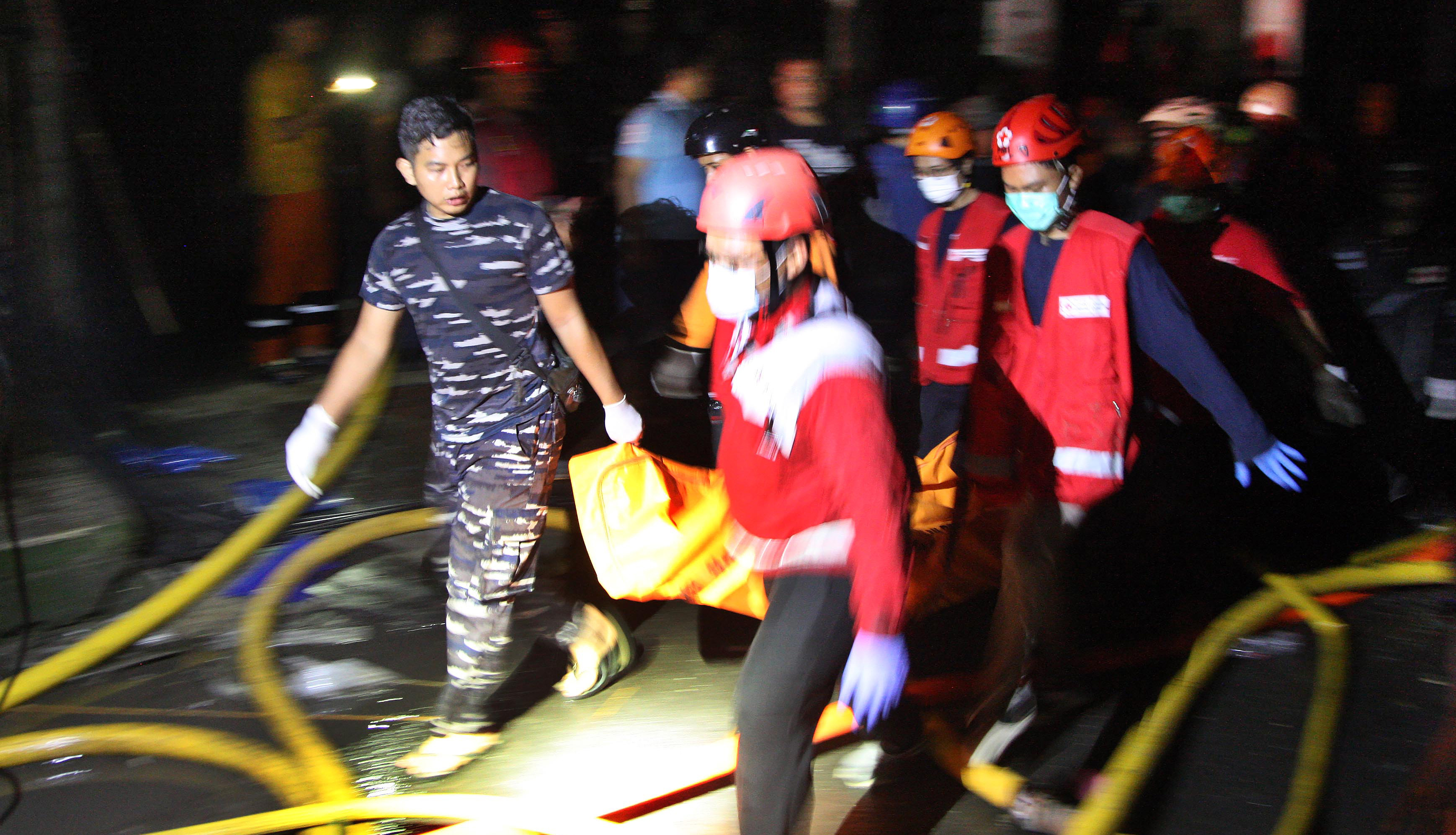 Petugas mengevakuasi jenazah korban kebakaran Depo Pertamina Plumpang (3/3/2023).