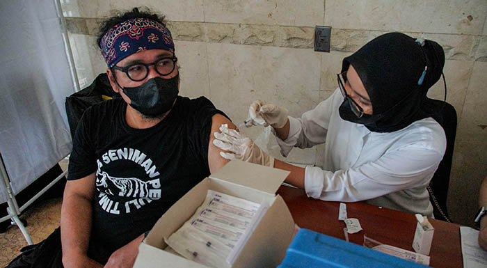 Petugas medis menyuntikkan vaksin covid-19 dosis keempat kepada karyawan Media Group di Kompleks Kedoya, Jakarta