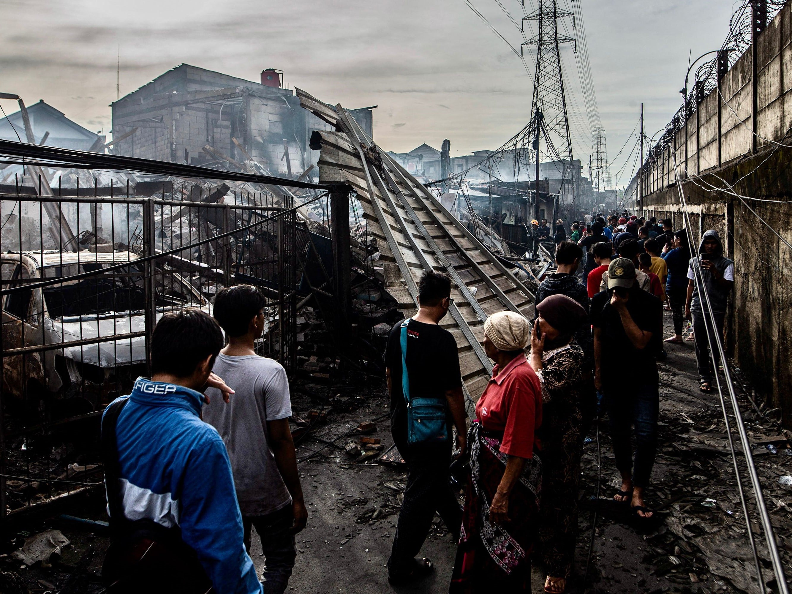 Orang-orang melihat rumah-rumah yang terbakar di kawasan perumahan di Plumpang, Jakarta Utara, pada 4 Maret 2023.