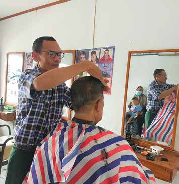 Pangkas rambut Rahmat tetap melayani pelanggan saat Ramadan di Jalan Saptamarga, Kecamatan Tawang, Kota Tasikmalaya.